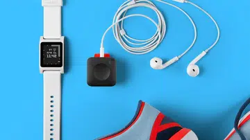 The Pebble Core is the square-shaped device connected to a pair of earphones.