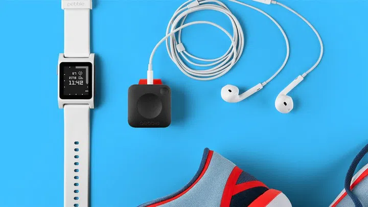 The Pebble Core is the square-shaped device connected to a pair of earphones.