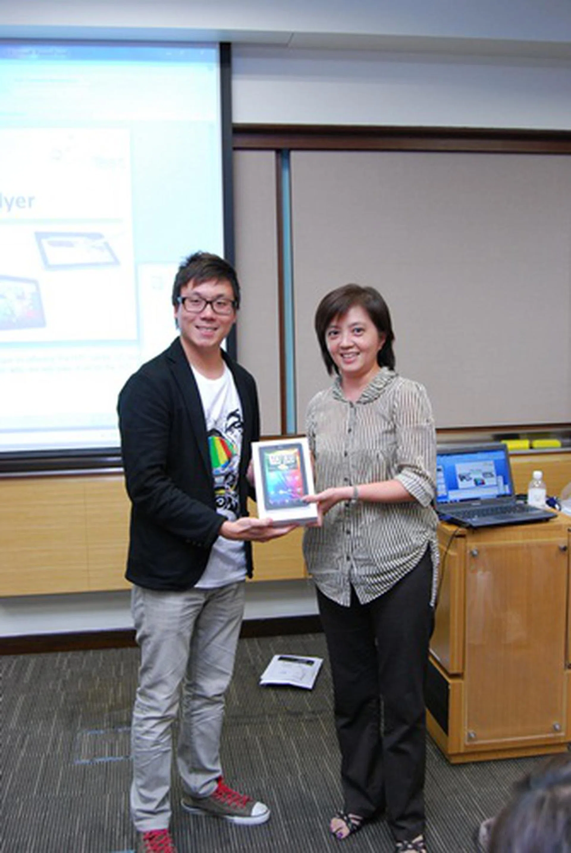 The lucky winner of the HTC Flyer, Ms. Sng Swee Lian, posing beside Mr. Wayne Tang, Product Manager of HTC Singapore.