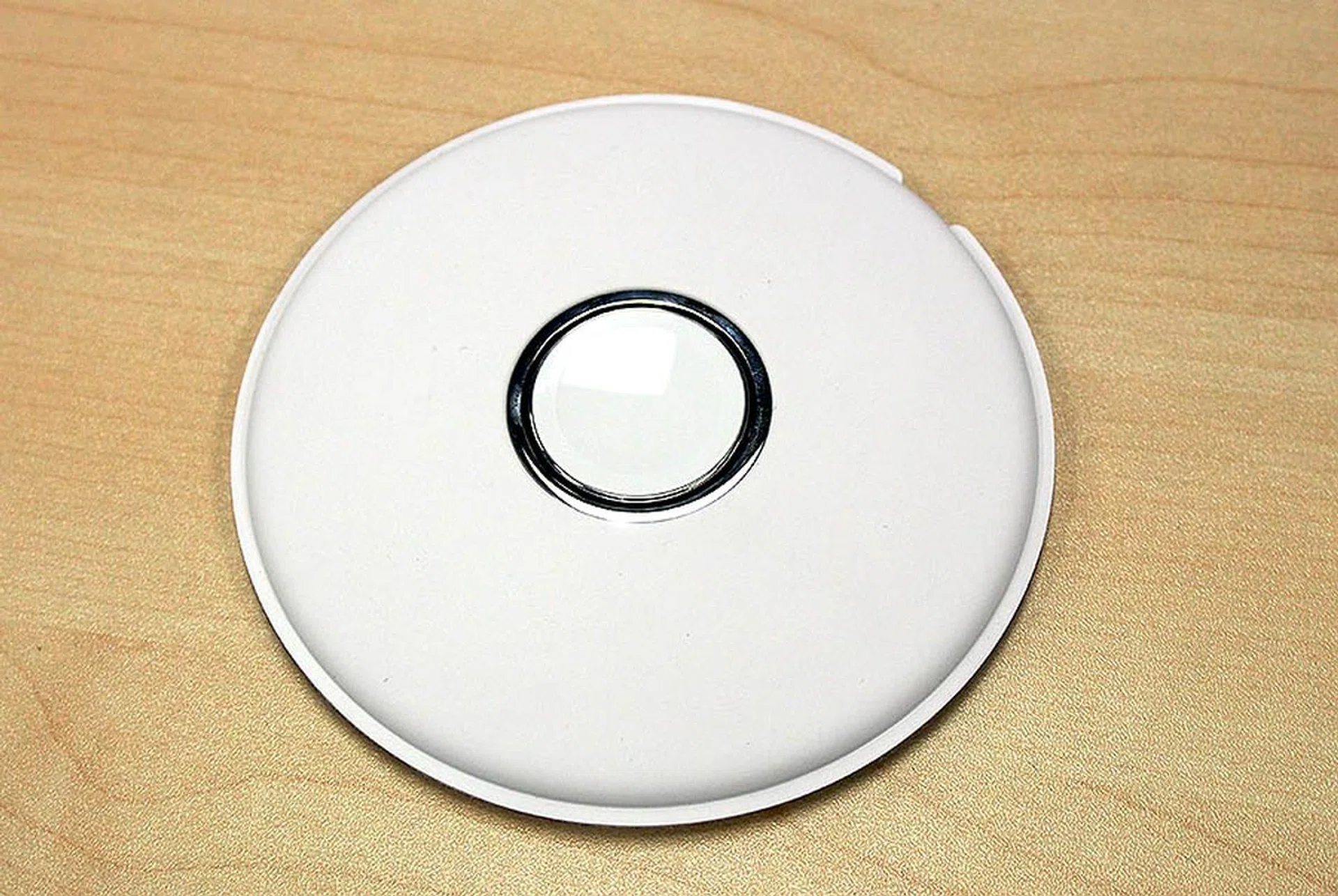 The Apple Watch magnetic charging dock looks like a white hockey puck.