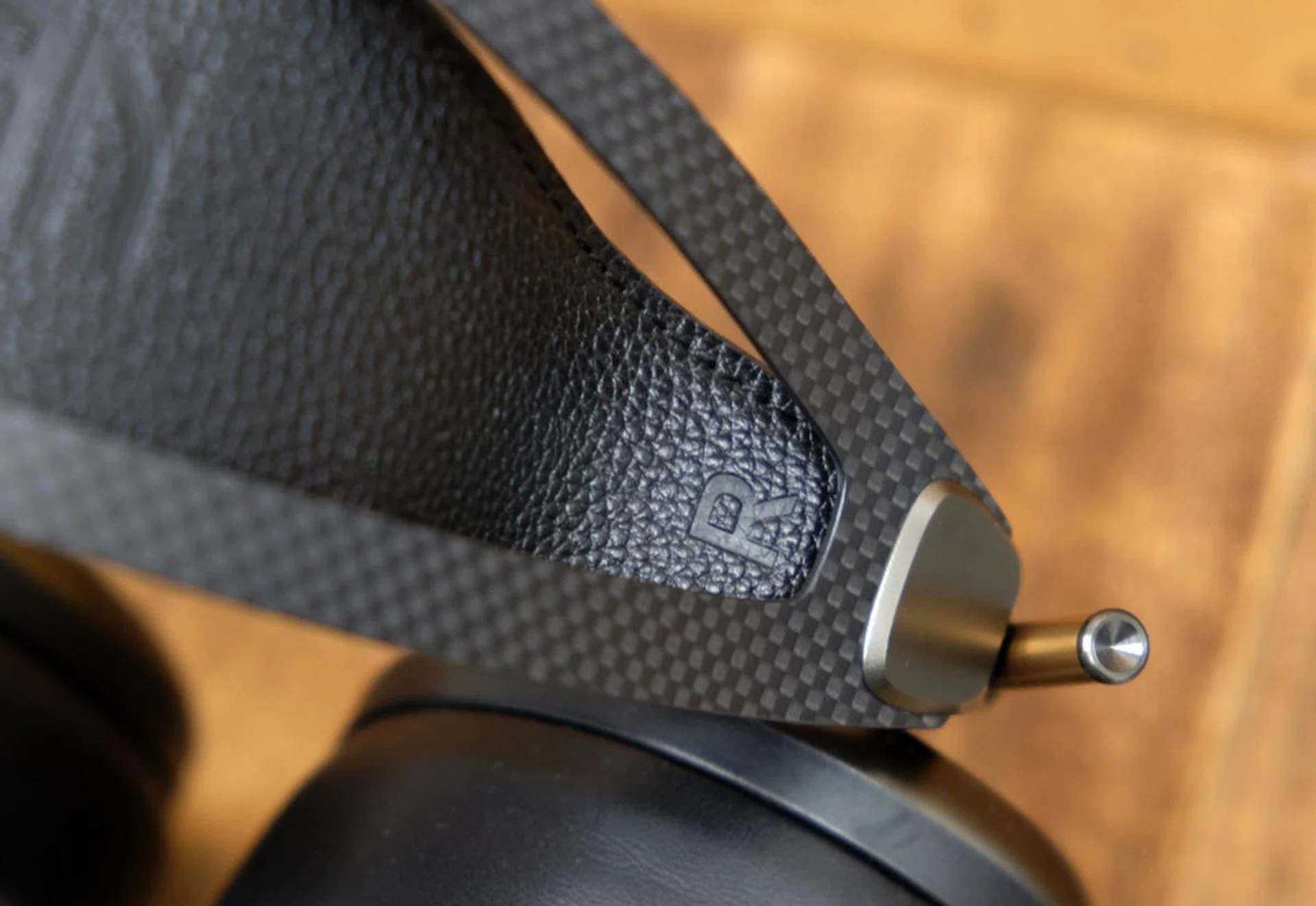 The head band is carbon fiber while the strap is genuine leather. Note the spring metal wings which aid weight distribution on the head.