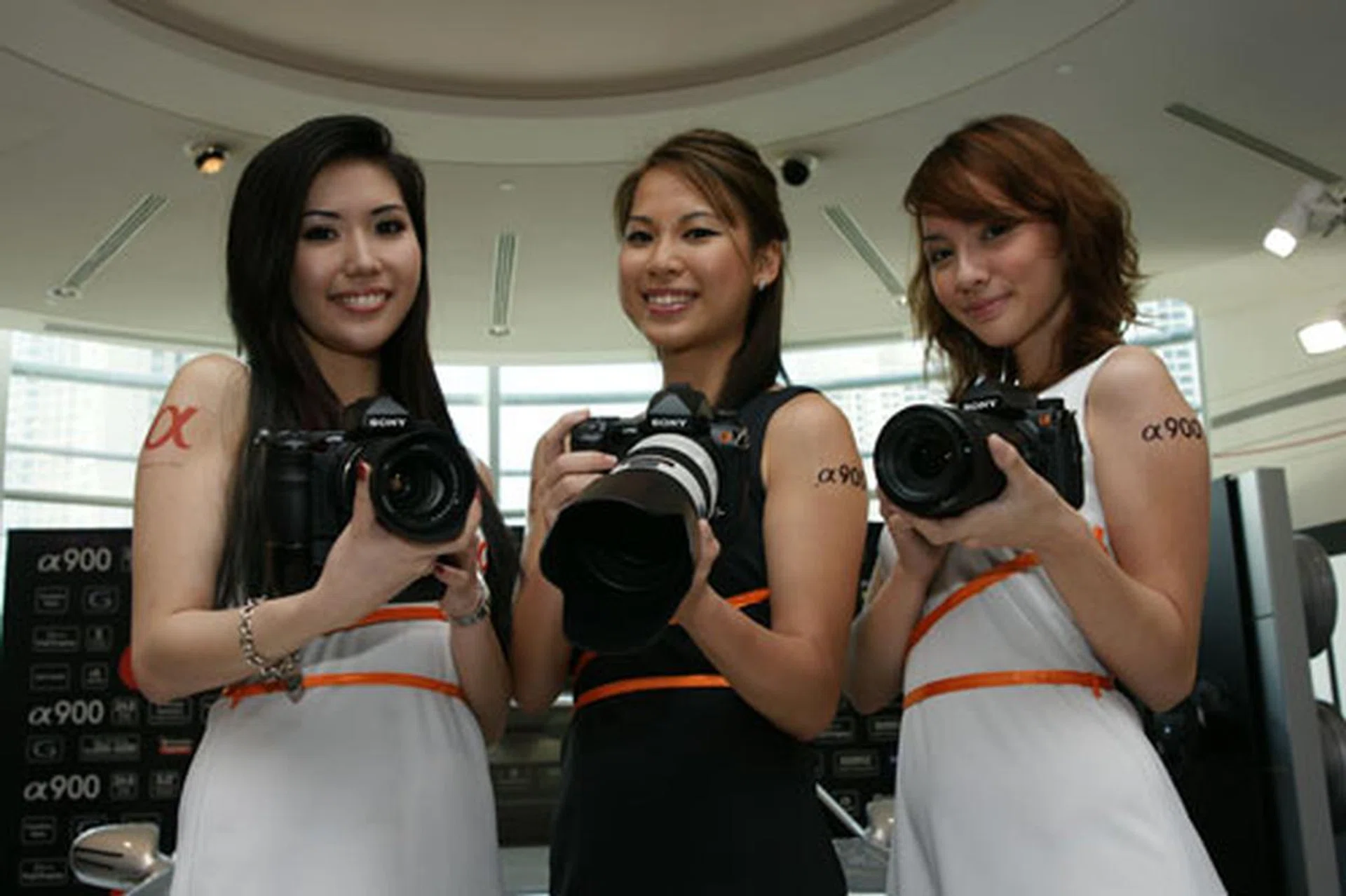 Three lovely models show the A900s off to the media.