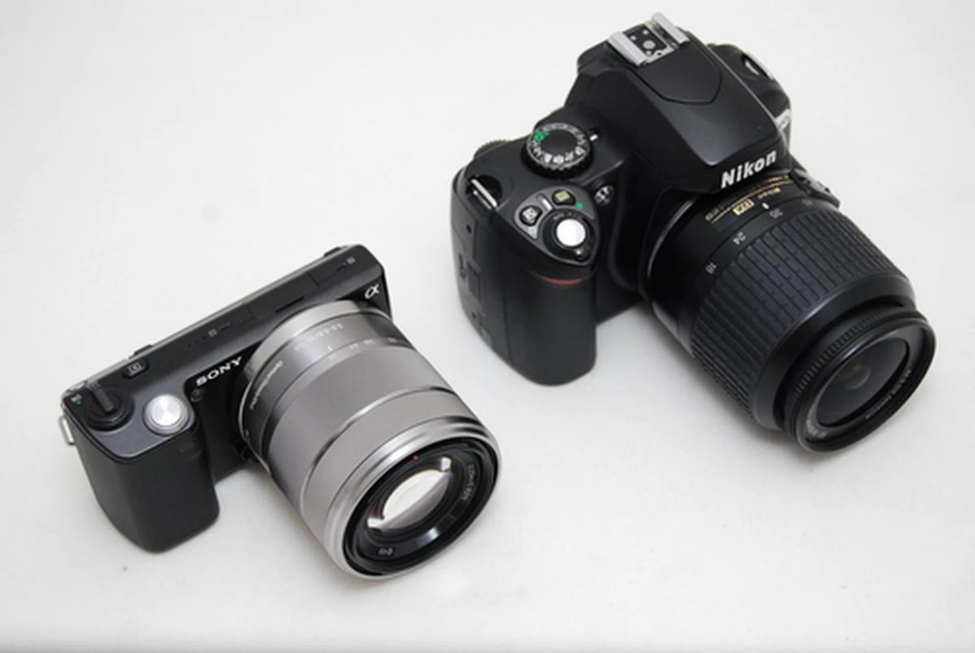 A size comparison between the NEX-5 and a Nikon D40x, both cameras with an APS-C sized sensor.