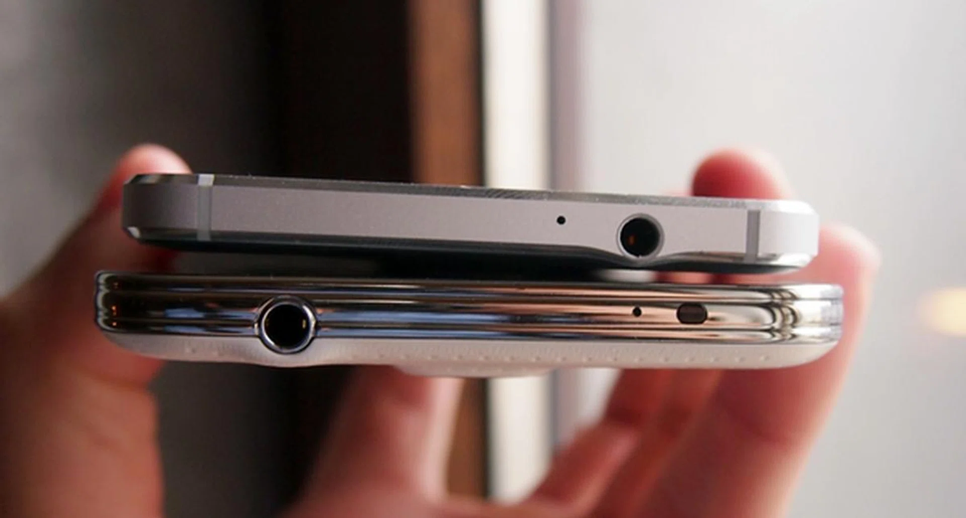 The Samsung Galaxy Alpha (top) has a different design approach compared to the Galaxy S5 (bottom). 