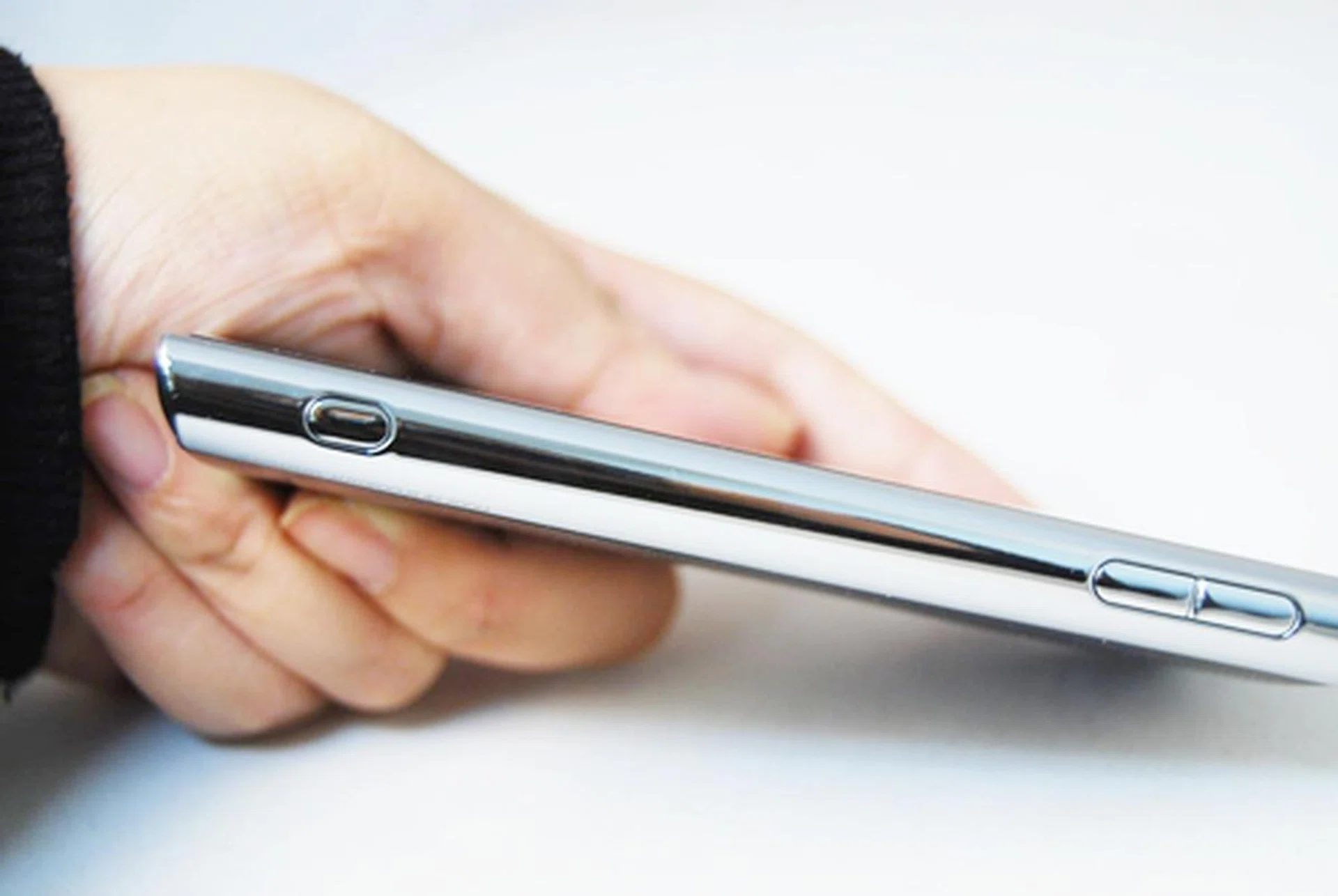 A dedicated shutter button sits at the bottom of the phone's right profile.