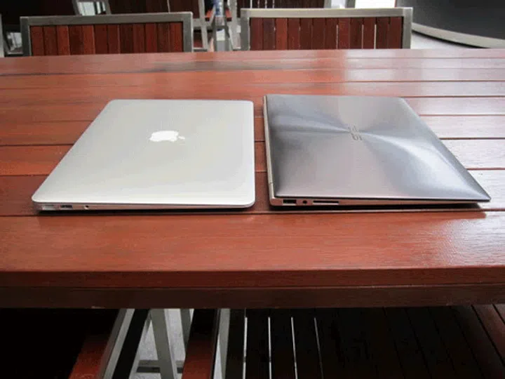 They have a similar form factor, but the ASUS ZenBook has several design differences; most notably the color, followed by the circular swirl that on the lid.
