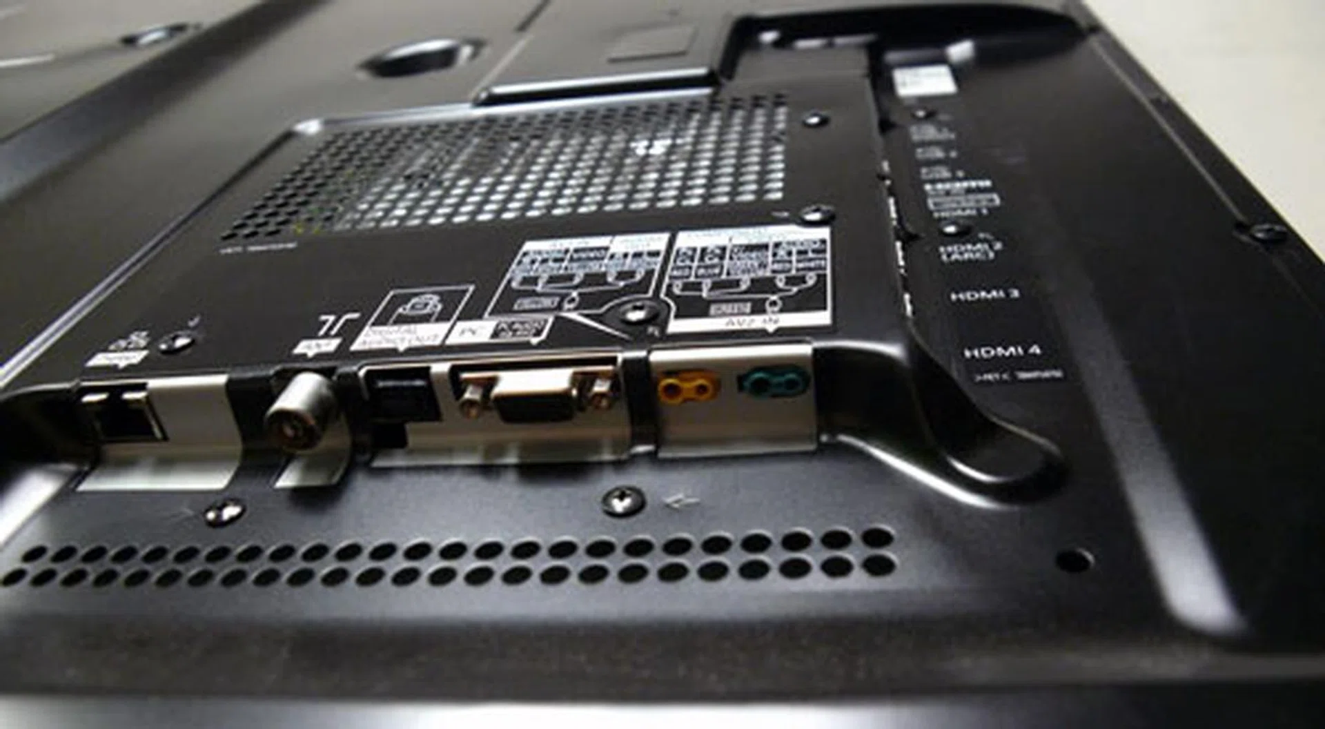 The proprietary composite inlet for the breakout cables is highlighted in yellow, and component in green. Others positioned along the bottom row include a LAN port, RF input, optical out, and VGA.   