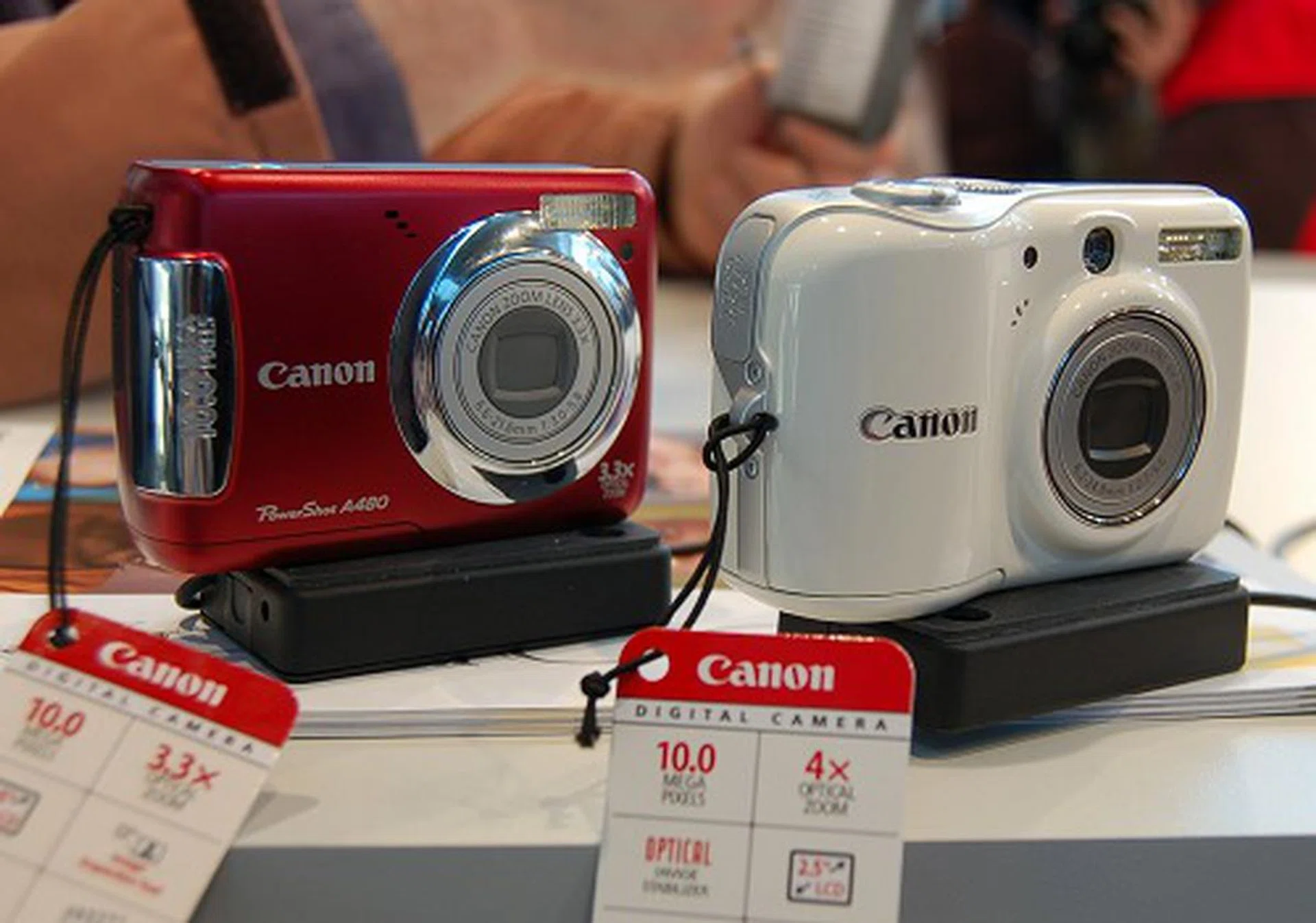  The Canon Powershot A480 (in red) uses a 1/2.3-inch 10-megapixel sensor, is capable of 3.3x optical zoom and comes with a 2.5-inch LCD screen. The Powershot E1 (in white) comes with a 10-megapixel sensor too and is more friendly on newcomers to digital cameras with its Easy mode shooting.  