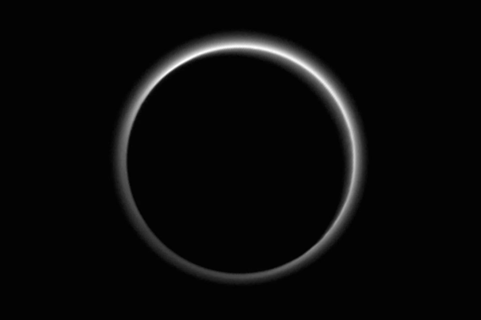 Pluto, backlit by the sun. Image credit: NASA.