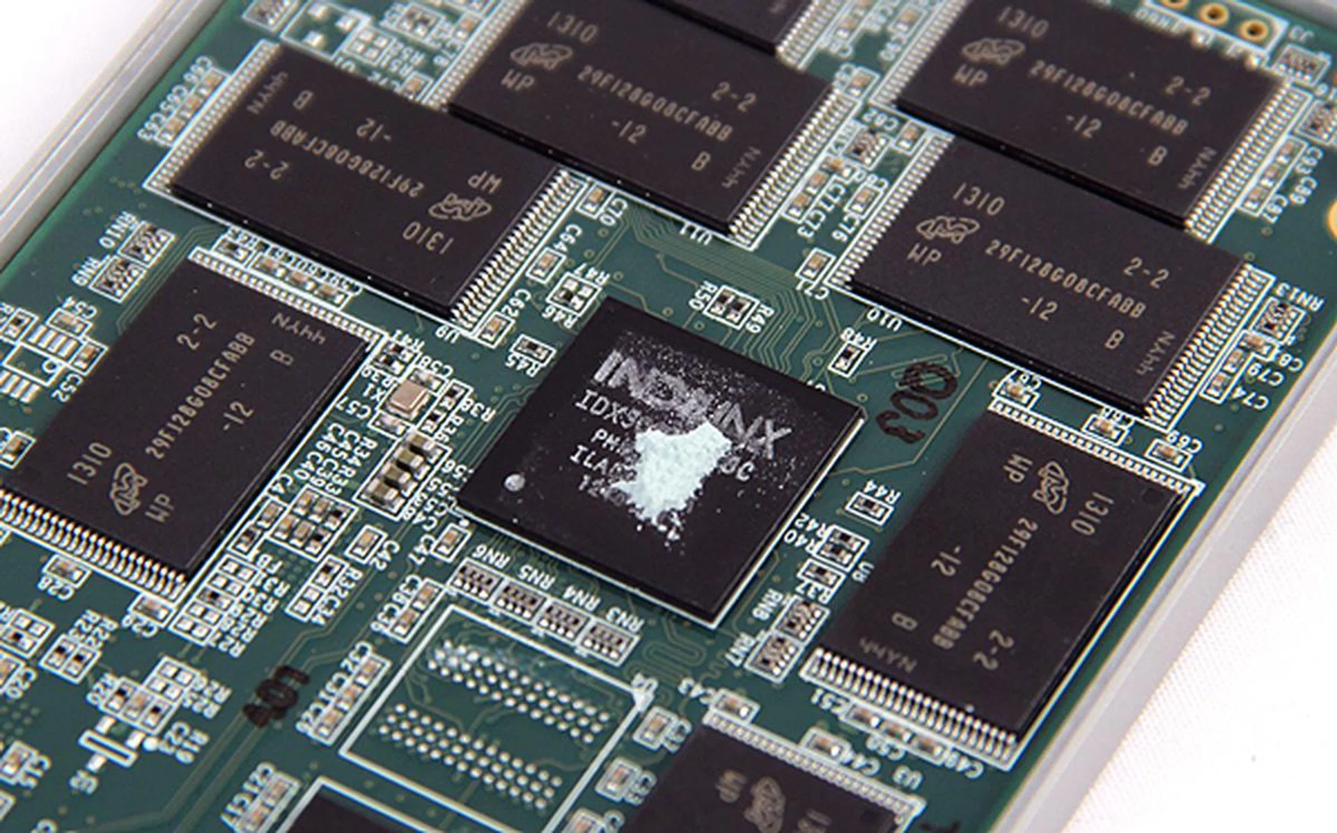 A closer look at the Indilinx Barefoot M10 controller surrounded by Micon's 20nm NAND chips. These NAND chips are of 16GB density, which means there's eight on each side of the PCB for our test drive's 256GB capacity.