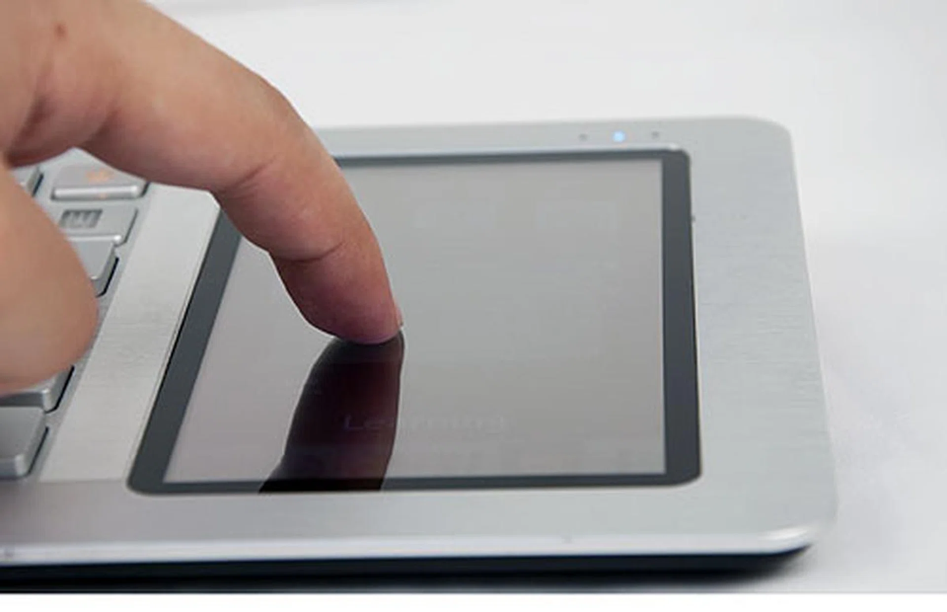 Because it's a resistive touchscreen, it requires a harder press. It would be nice to have a capacitive screen, but that would probably drive up the cost. For what its worth, the current resistive screen works as it should both as a navigator for the app launcher and a trackpad when connected to a monitor. Also, it seems the retail model will feature separate right and left click buttons. 