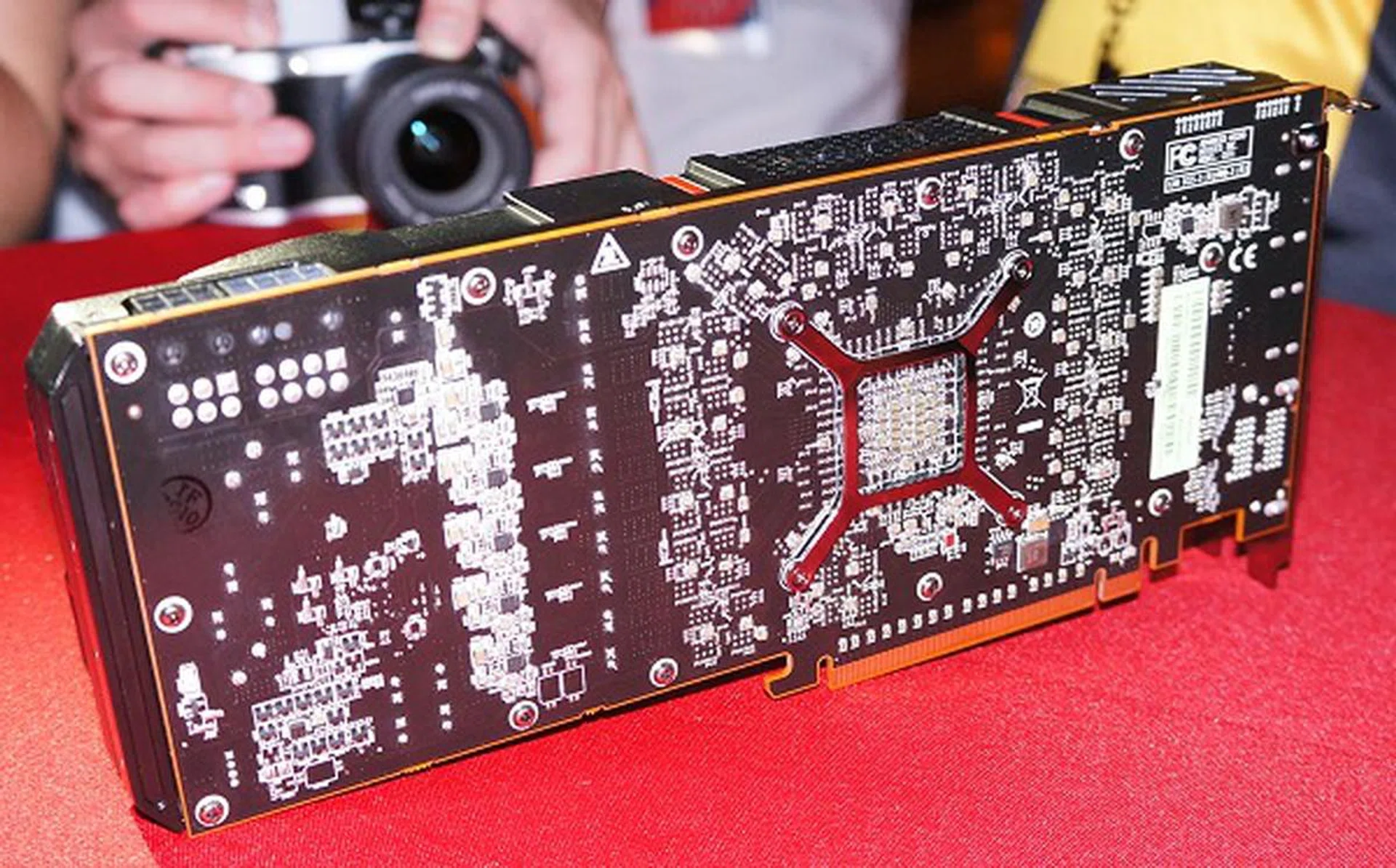 Over at the rear side of the card, this reference unit is left bare and you can notice solder ball joints of the numerous memory chips that are mounted on the forward side of the PCB. We counted a total of 16 memory IC spots, which should total up to 4GB of graphics memory (GDDR5) screaming at 5000MHz on a wide 512-bit memory bus.