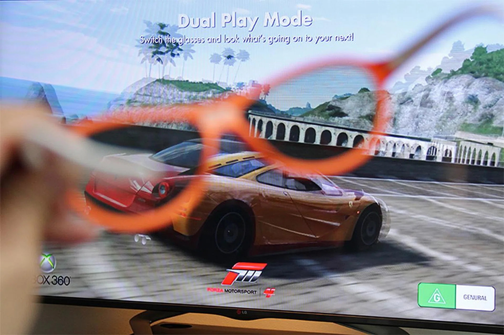 For two-player games, instead of splitting the screen, Dual Play allows the whole screen to be used by each player. This is done by transmitting two separate 2D images that can be seen through two different sets of polarized glasses. In this example, this pair of glasses can only see the red car; the other pair will only see the yellow car.
