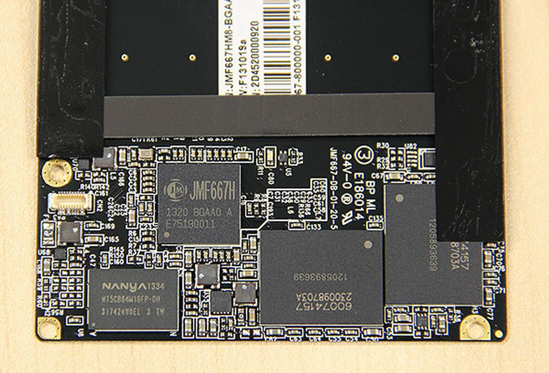 The JMicron 667H is to the left and to the bottom left of it is a Nanya DRAM chip for caching purposes. Capacity is provided for by two 64GB MLC NAND chips sourced from IMFT.