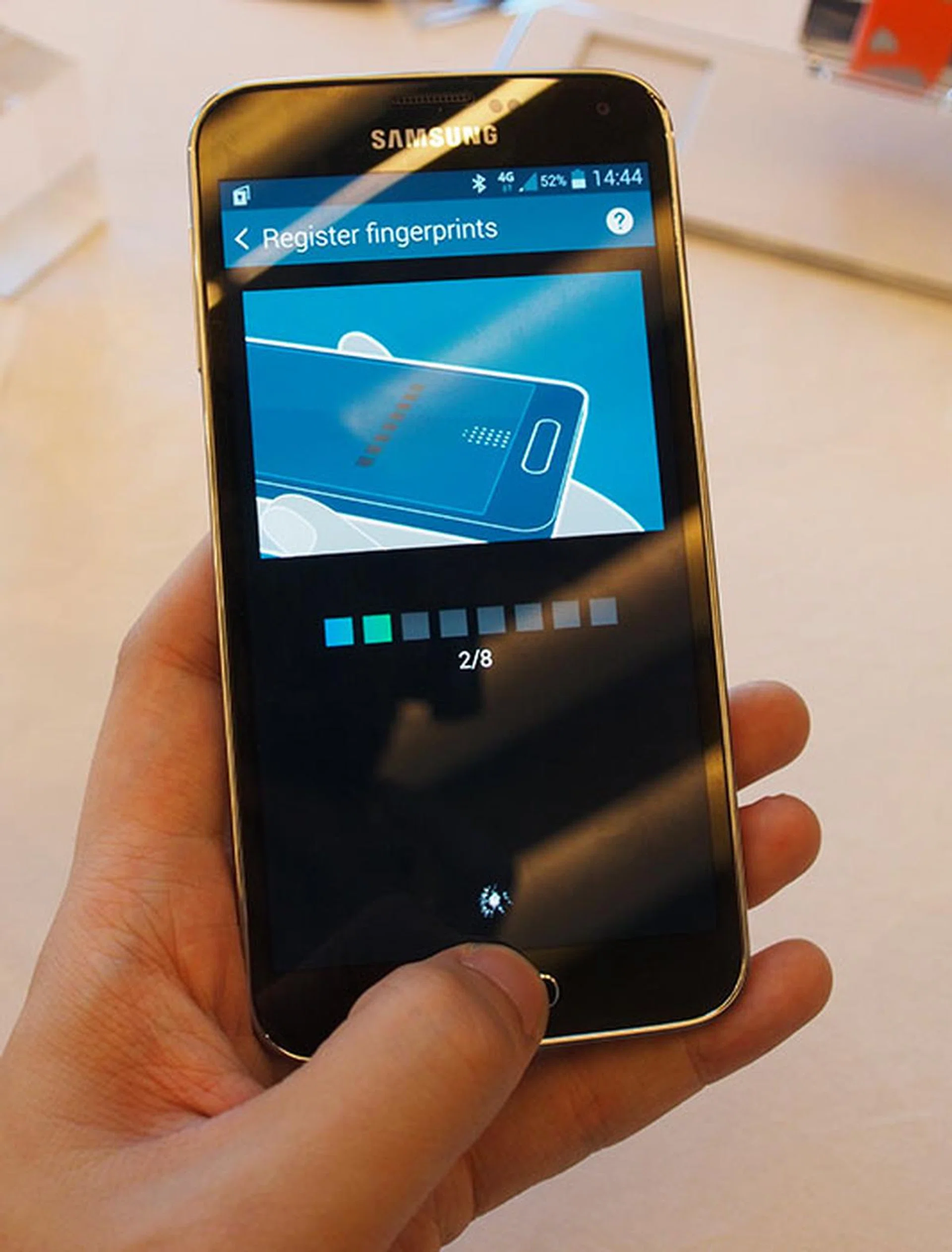 Unlike Apple's 5S sensor, which just requires you to place your finger on the button, the S5 requires a downward swiping motion, indicated by the little dots above the home button in the demonstration picture.