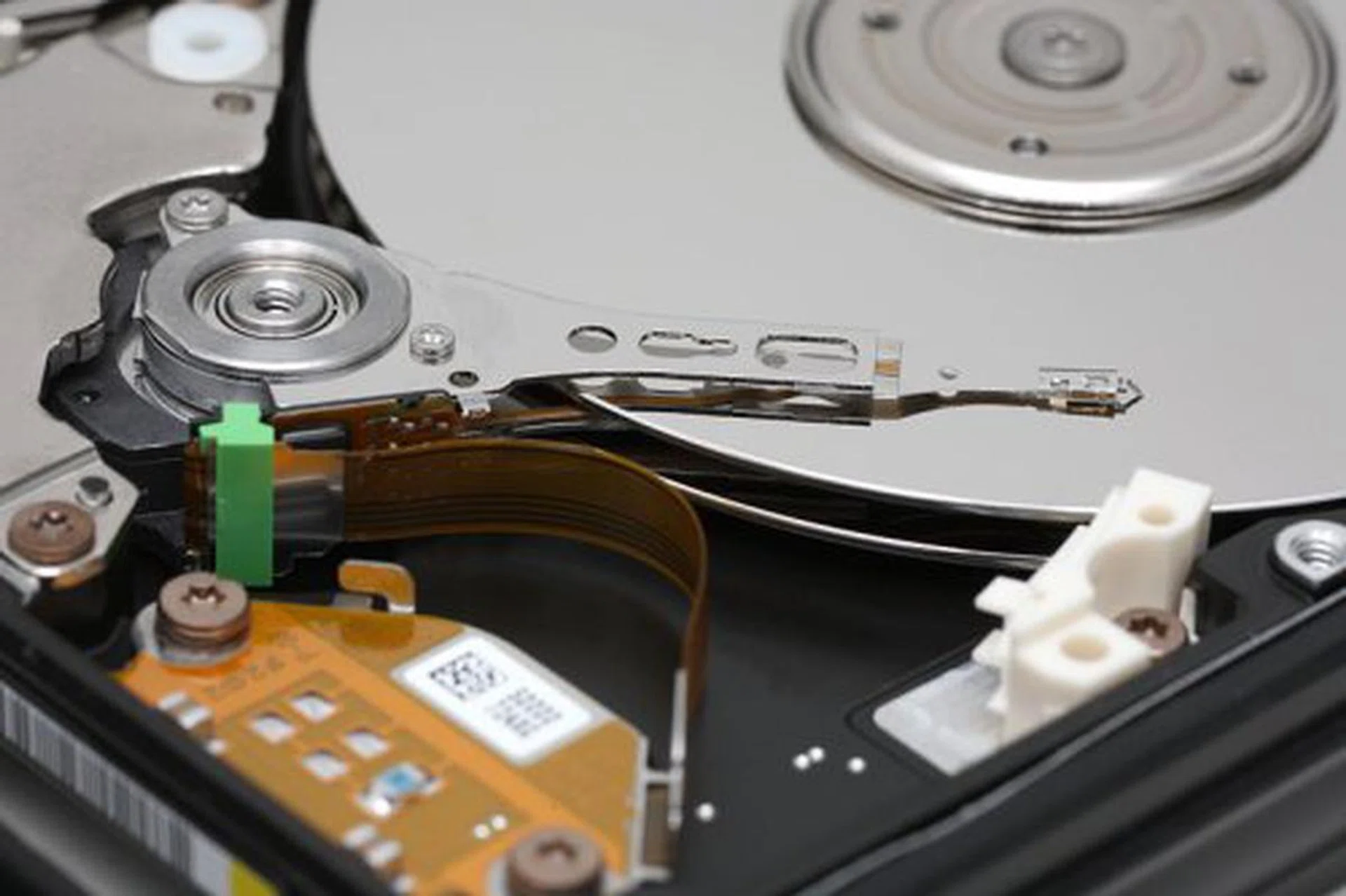This is what a traditional hard disk looks like (image courtesy of Wikipedia). The platter, spindle, head and actuator arm are all clearly visible.