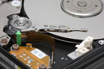 This is what a traditional hard disk looks like (image courtesy of Wikipedia). The platter, spindle, head and actuator arm are all clearly visible.