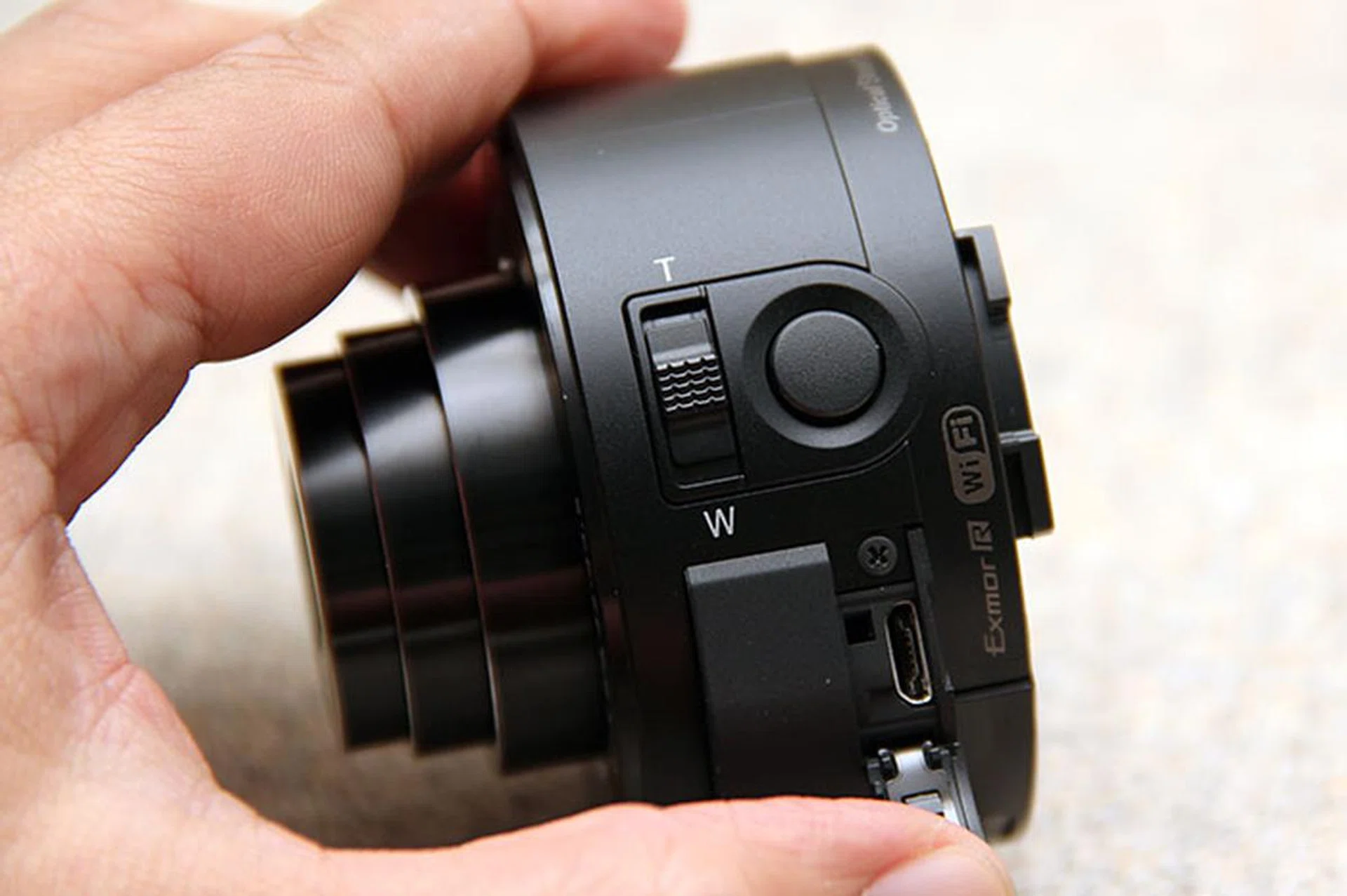 On the left, you've the zoom lever, shutter button, and micro-USB terminal (under the flap). 