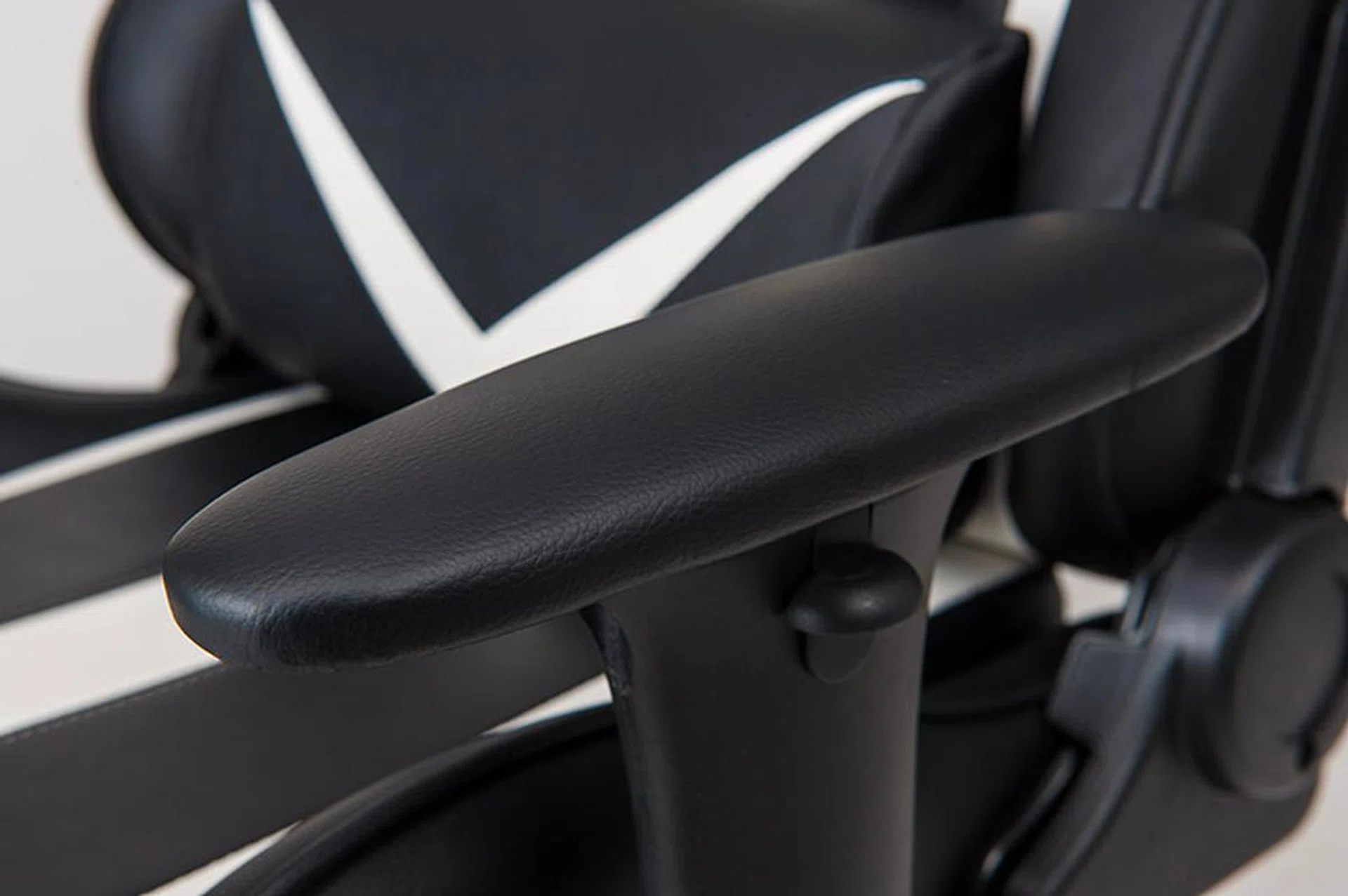 The armrests feature generous leather padding and can be adjusted by pushing the button on the outer edge.