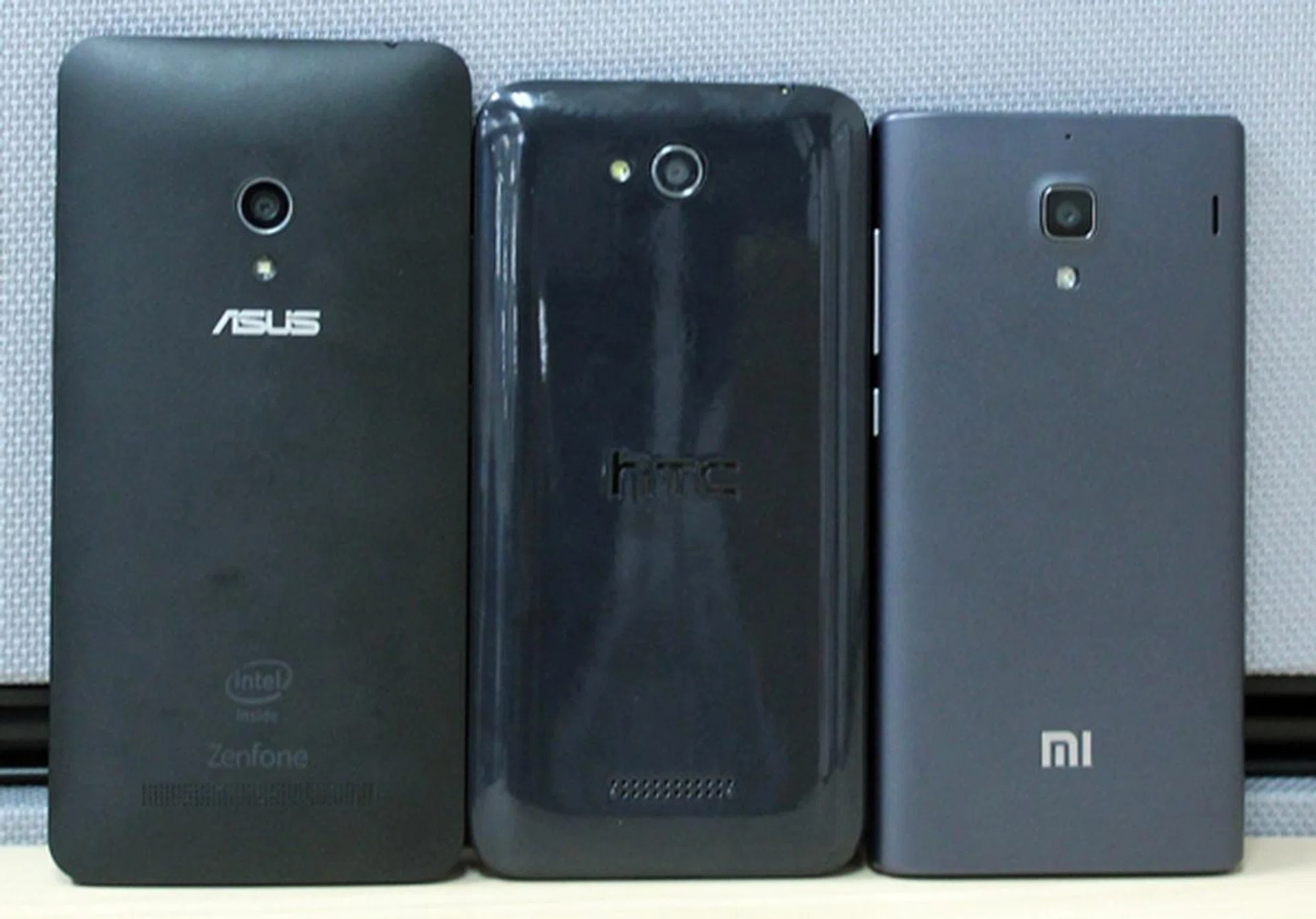 The rear shot of the three phones. <br> Left to right: ASUS ZenFone 5, HTC Desire 616 and Xiaomi Redmi 1S.