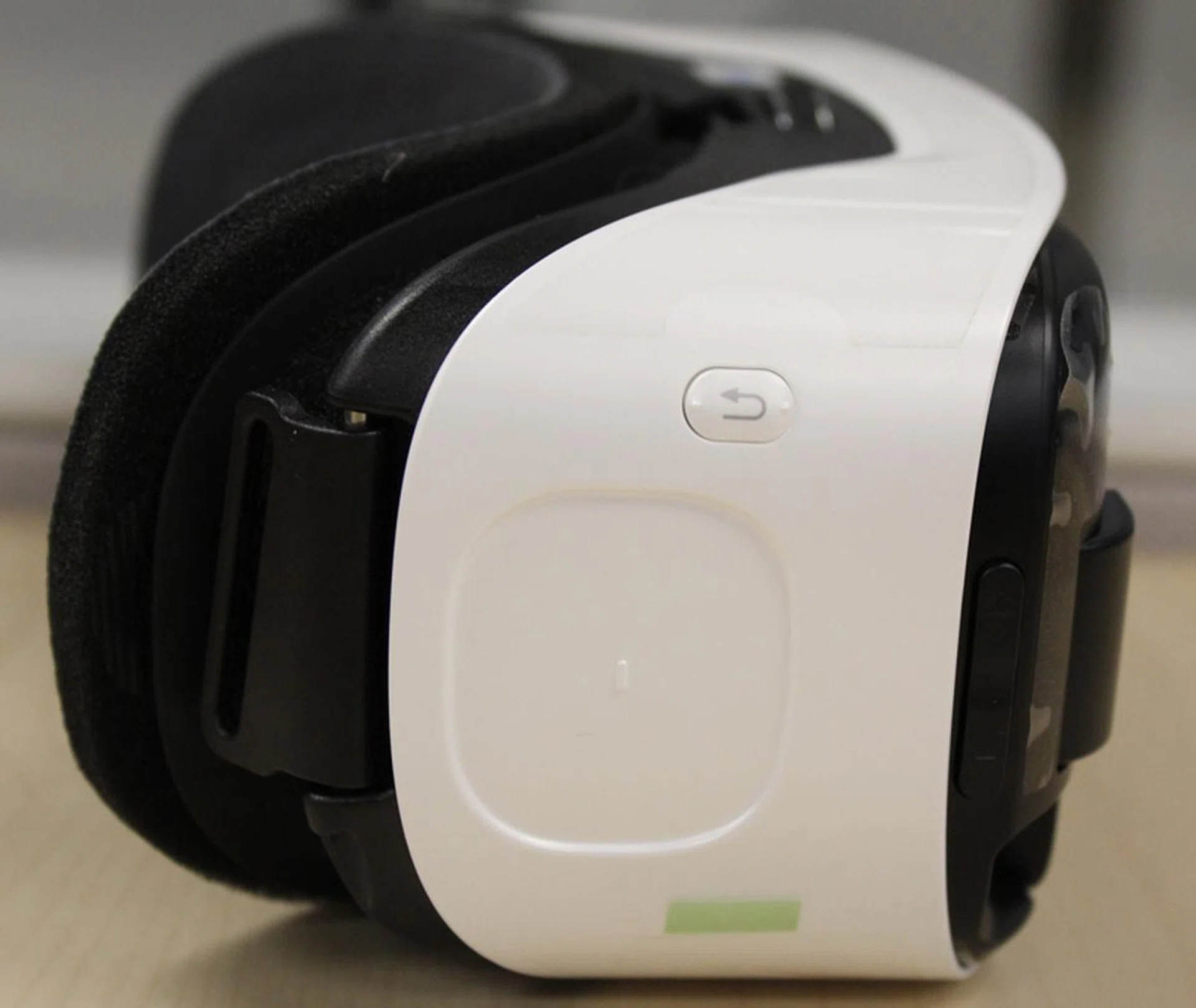 The back button (the button with the curved arrow) and the trackpad (the recessed squarish area below the back button) are both on the right side of the headset.
