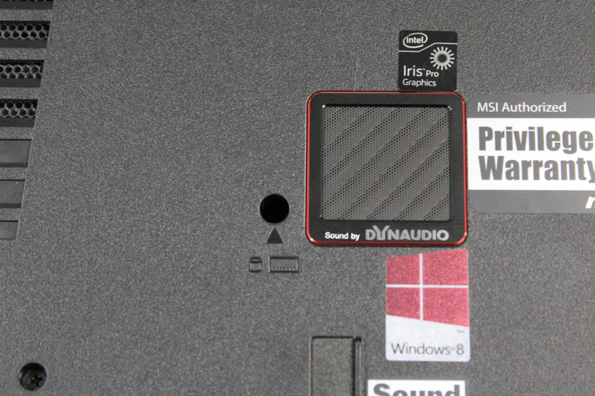 The symbol used to show which screw to remove to access the components could really have been larger. Note also the subwoofer to the right of the screw.