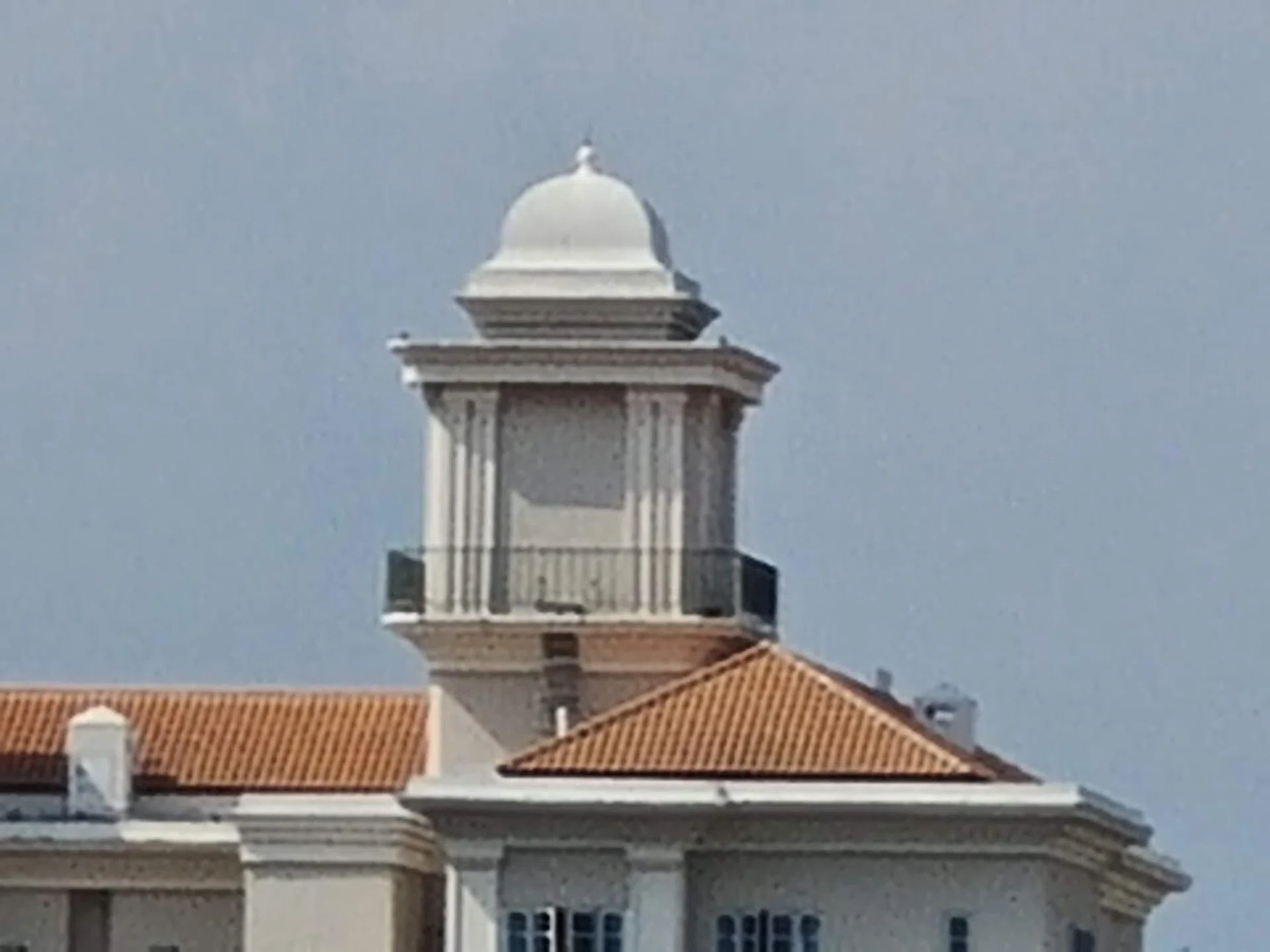 Galaxy S20/S20+, 30x hybrid zoom. The image has a lot of processing artifacts, but the texture in the roof tiles is retained, and you can still make out the railings.