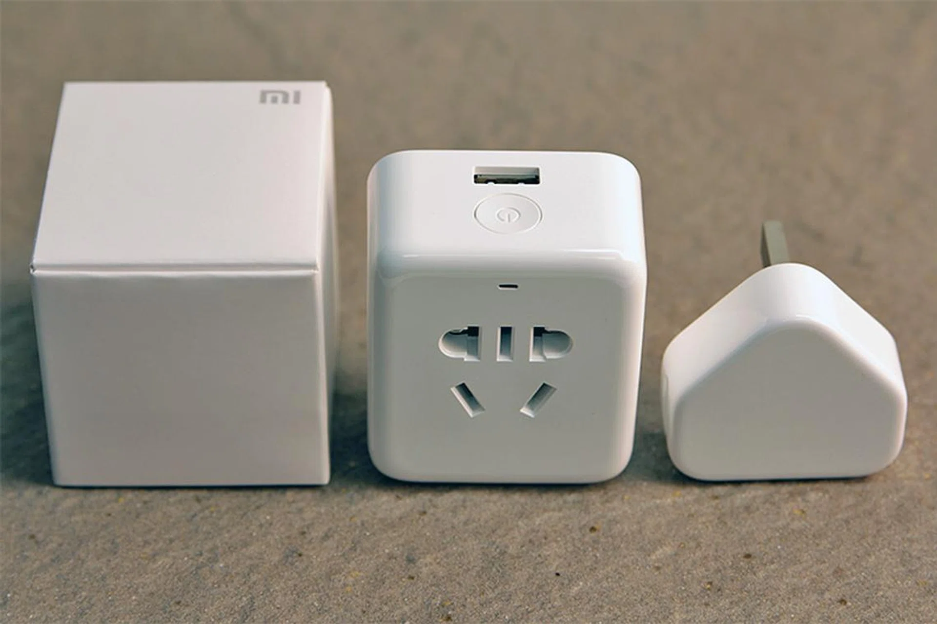 The Mi Plug (middle) beside the box it comes in and a regular iPhone USB power adapter.