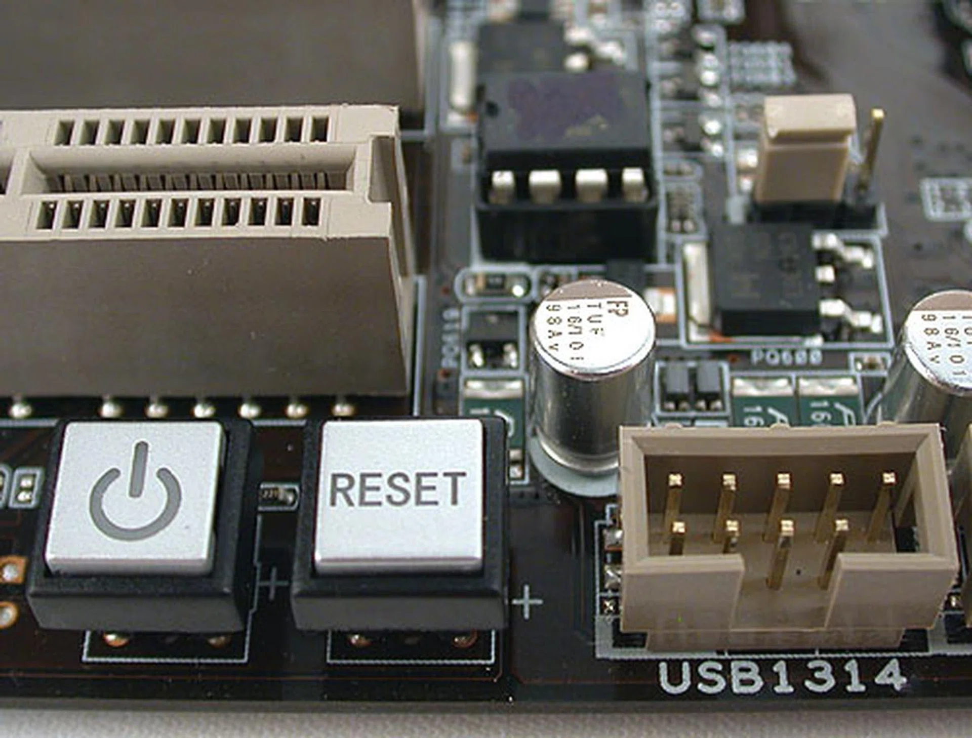 The onboard power and reset buttons. You'll notice a jumper at the top right corner. This is the Clear CMOS jumper to restore the BIOS to default. Again, we were rather surprised to find ASUS going with jumpers and not the usual Clear CMOS button. Perhaps the cost factor comes in for a mainstream board.