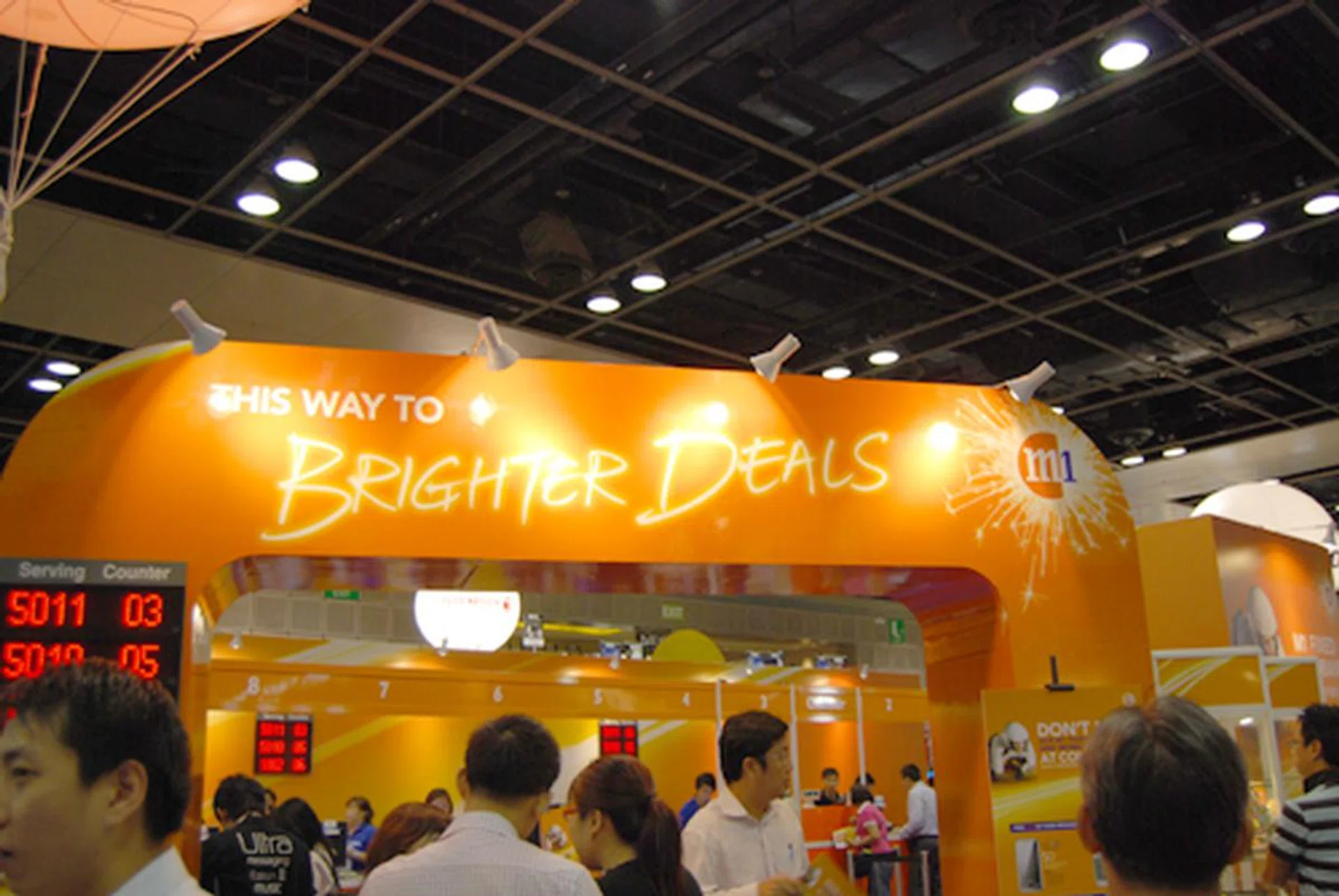  Things seem definitely brighter for M1 with their very own booth at level 4, while SingTel is content with their iPhone 3G sales back at their ComCentre headquarters.  