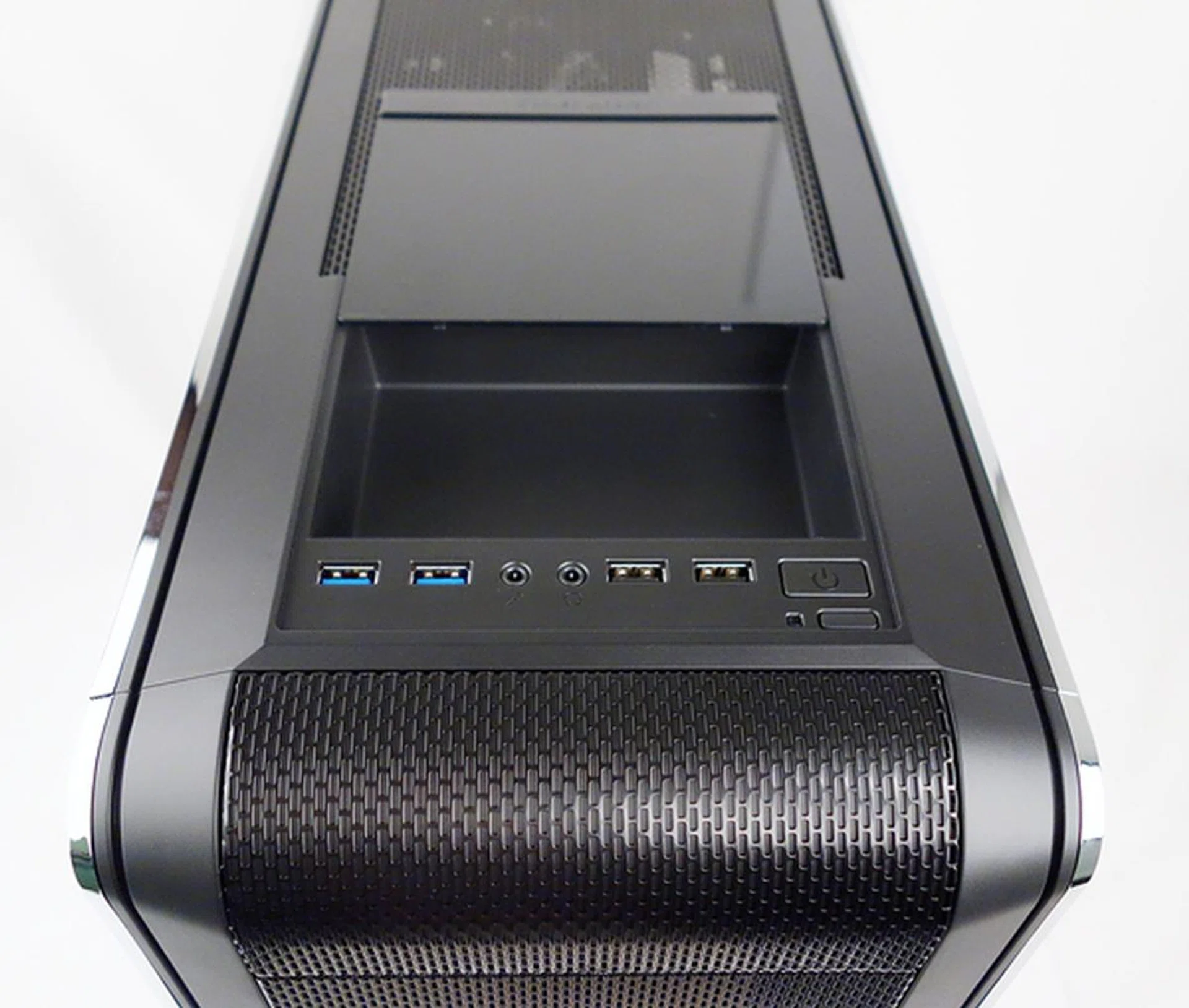 The I/O ports and onboard buttons line the edge of the storage space. The storage compartment has a removable sliding plastic cover, which can protect the ports too.