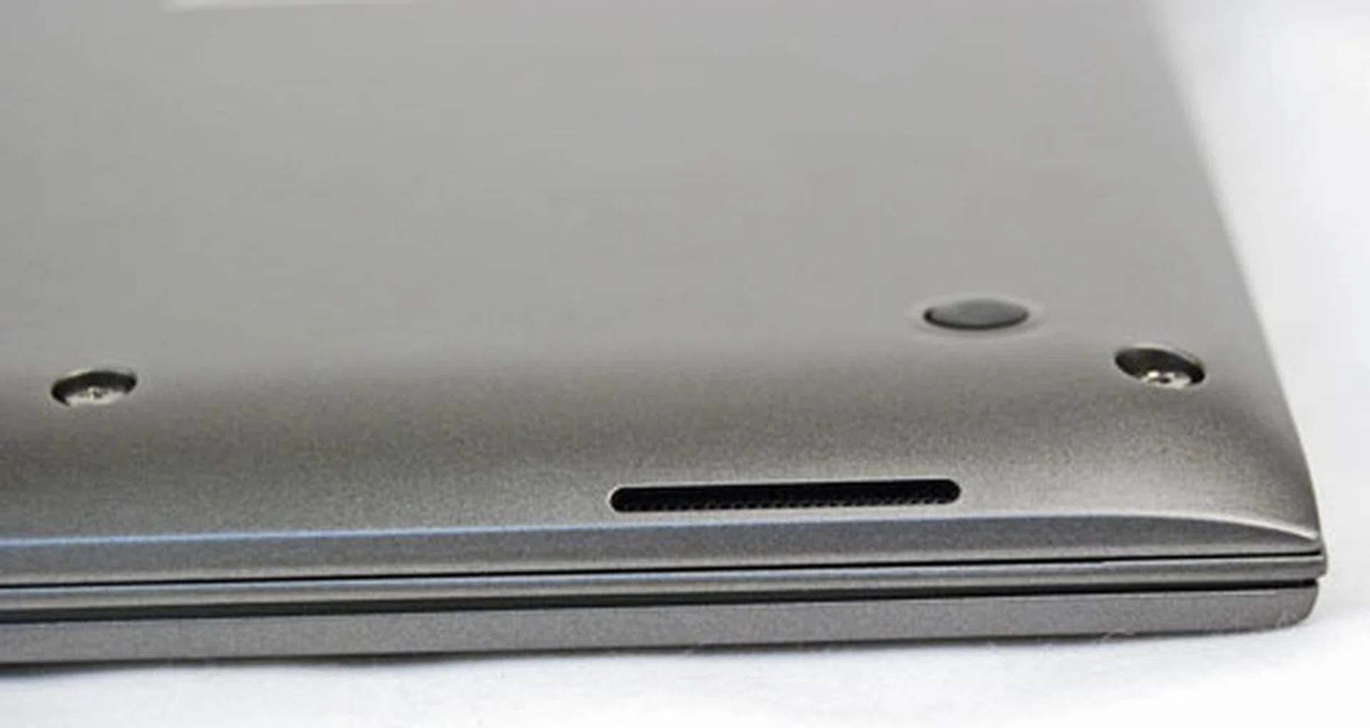 The speakers are located at the bottom of the machine, but aren't smothered when the machine is placed on the table. A slight curve at the bottom allows the speakers to breathe, bounce the audio off the table and be sufficiently audible. 