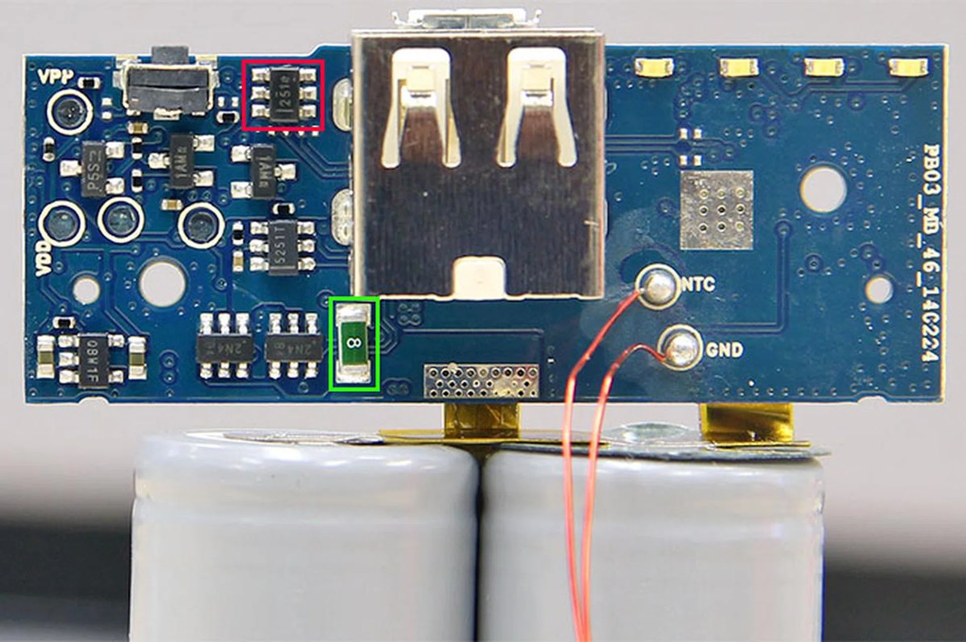 That thing in the red frame looks to be a Texas Instruments TPS2514 USB power and charging port controller. The one in the green frame is an 8A fuse. On its left are a few more transistors in SOT-23 package, which we believe are N-channel MOSFETs and protection IC to protect the battery during over-charge, over-discharge, and over-current situations.