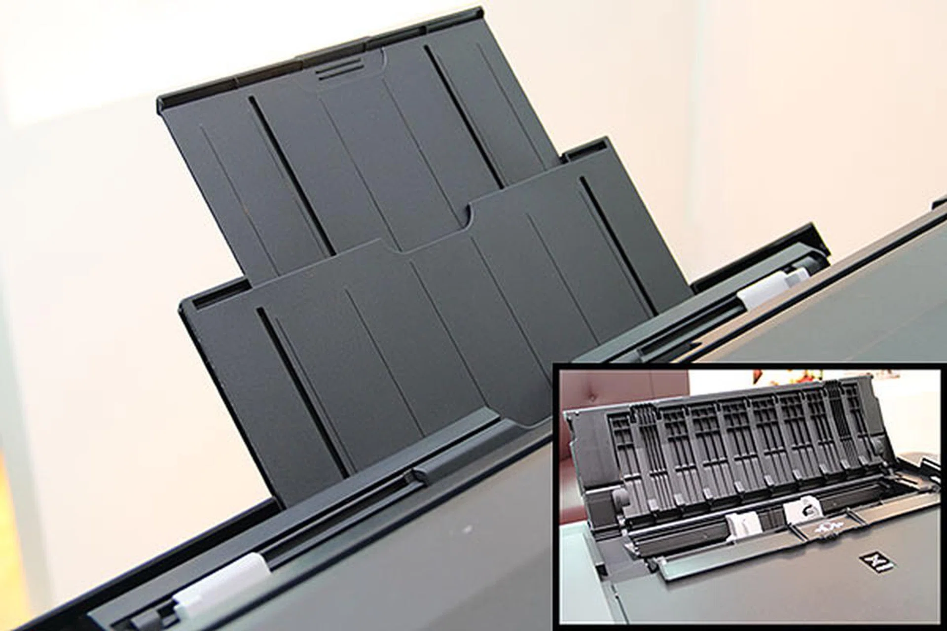 To make the device footprint smaller, the manual feed tray for thicker media is now at the rear, just behind the usual loading tray (inset). 
