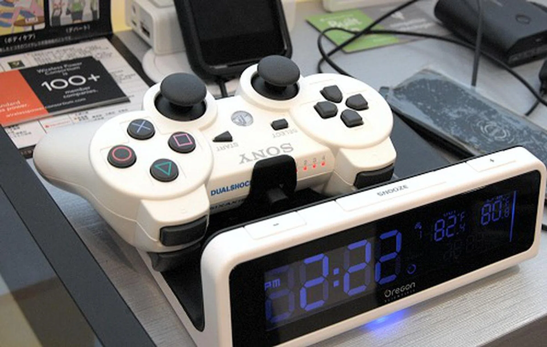 Oregon Scientific’s wireless power charging station (designed with the Qi standard) doubles up as large alarm clock with visual charging status indicators on the display. In this example, an adapter mounts to the PS3’s controller to act as a wireless power charging receiver and when placed on the flat charging area of the alarm clock, the PS3 controller starts to charge.