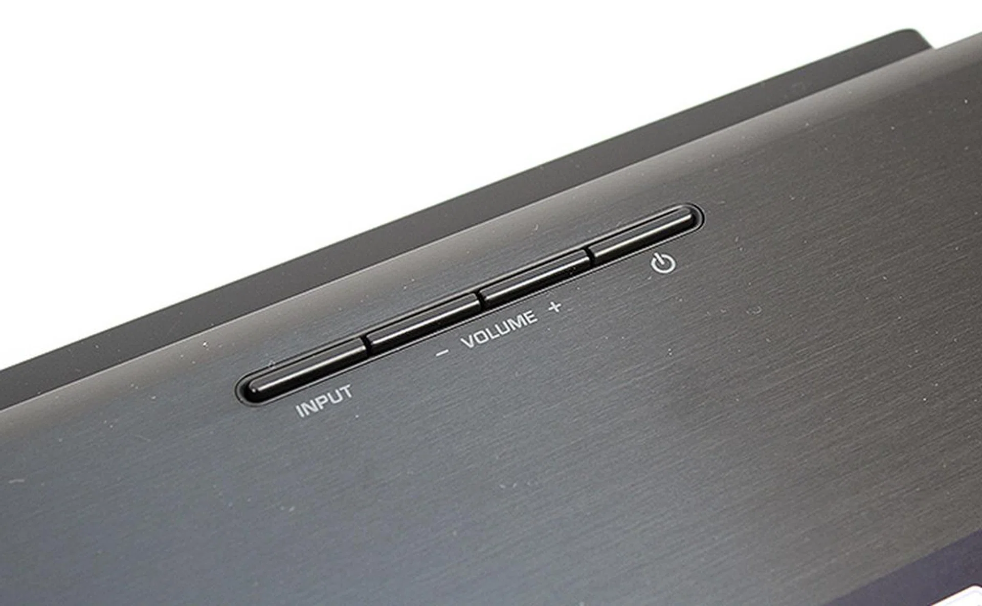 The center speaker unit sits relatively low, but it is wide. Note the brushed aluminum finishing on the chassis. There are only these four buttons on the speaker itself.
