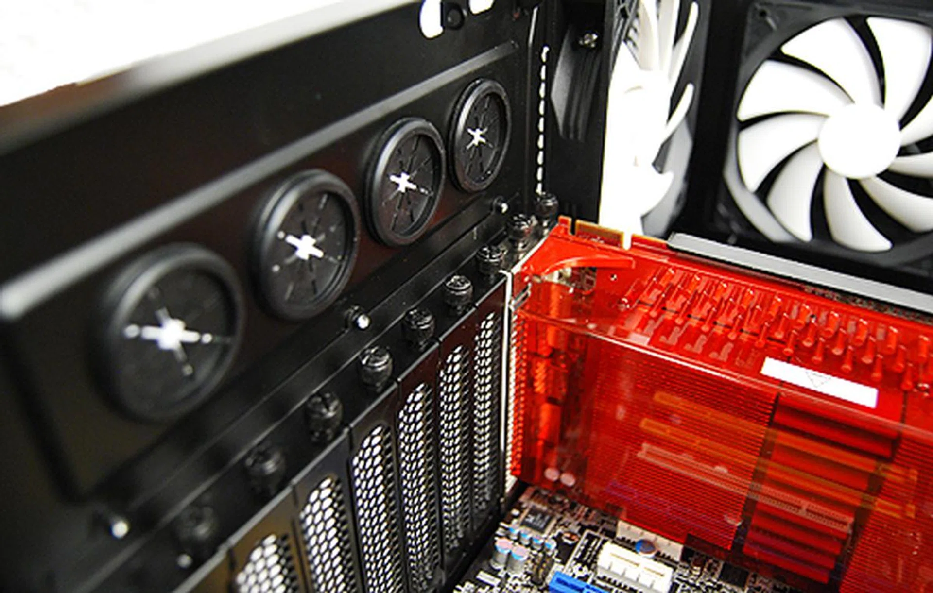 Installation of expansion bay devices such as graphics cards require you to undo thumbscrews. Seen are are also the four grommets for liquid-cooling setups.