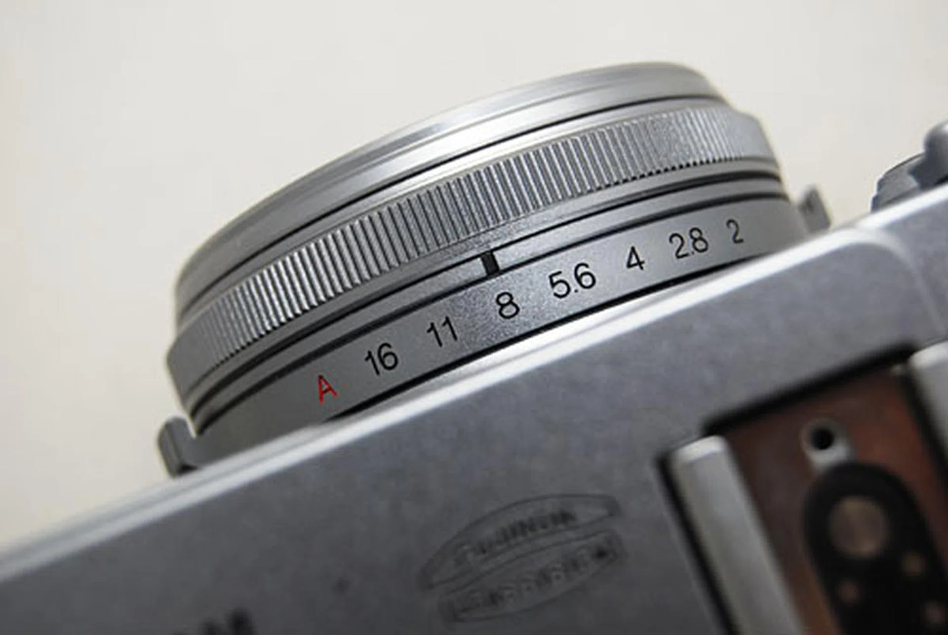 Set the aperture using the aperture ring around the lens. 'A' is for Automatic.