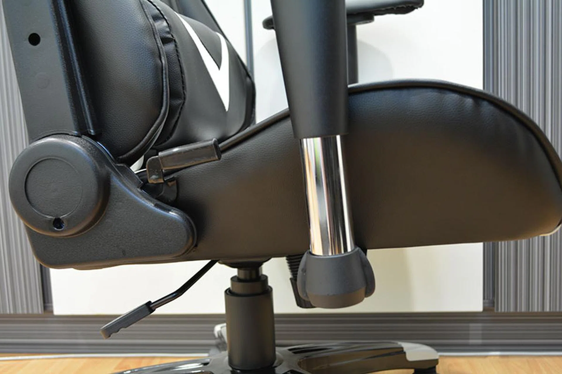 The height adjustment lever is located at the right side of the chair and angled toward the back.