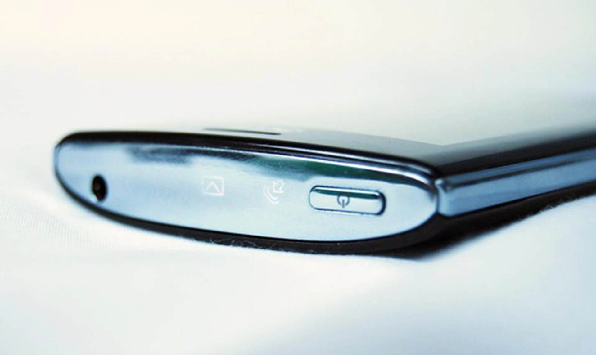 From left to right – battery status, an envelope/messaging icon, and an arrow symbol. The messaging icon pulses when there are unread messages, while the arrow symbol lights up to inform you of missed or incoming calls. Both the 3.5mm headphones jack and power button flank the sides.