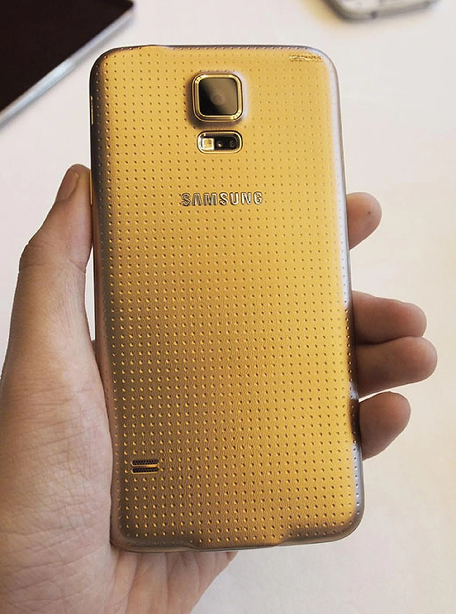 The back of the S5 is covered with dimpled micro dots, which provide an interesting textured surface. Like Apple, Samsung has opted for more of a copper-color gold.
