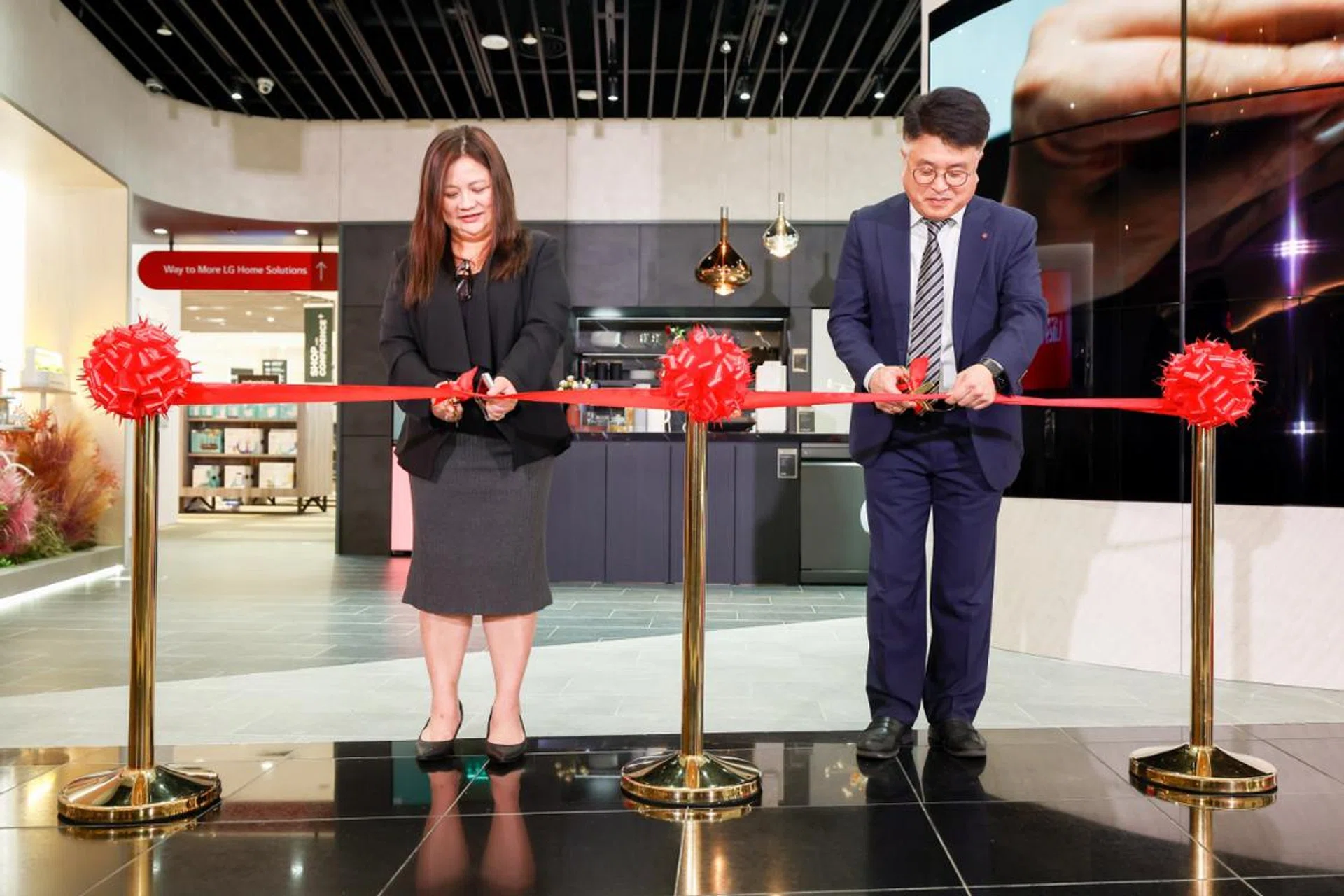 Bernice Kwok, Chief Operating Officer of Harvey Norman Singapore and Gerald Chun, Managing Director of LG Electronics Singapore, cutting the ribbon. Image source: LG.