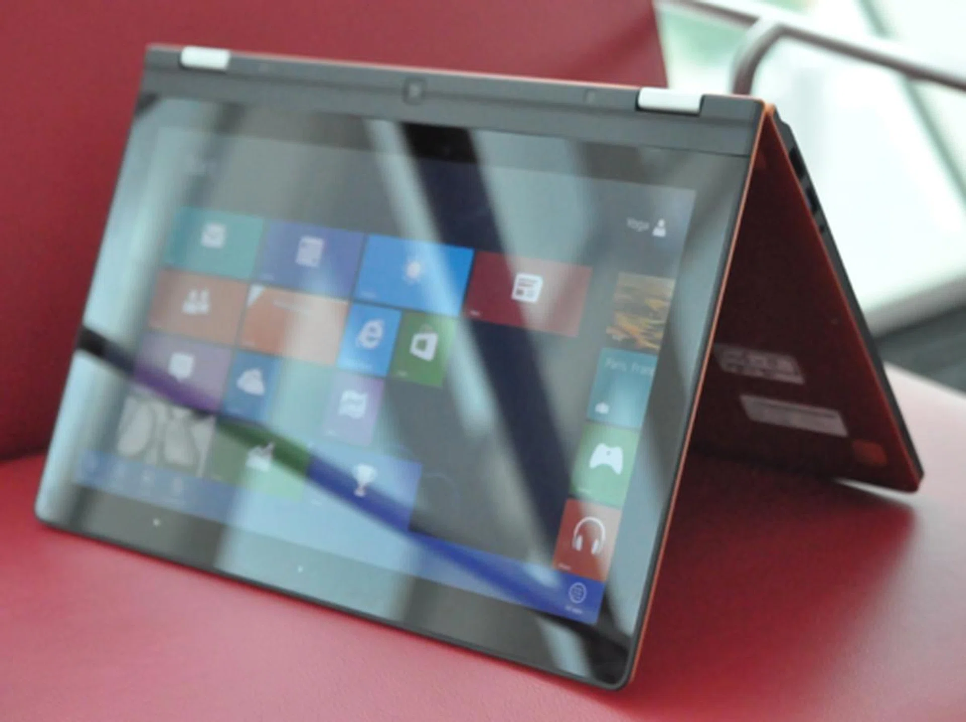 Simply reposition the notebook to "tent" mode, and the accelerometer in the notebook will take care of screen orientation. You can also completely close it to turn get the notebook into "tablet" mode.