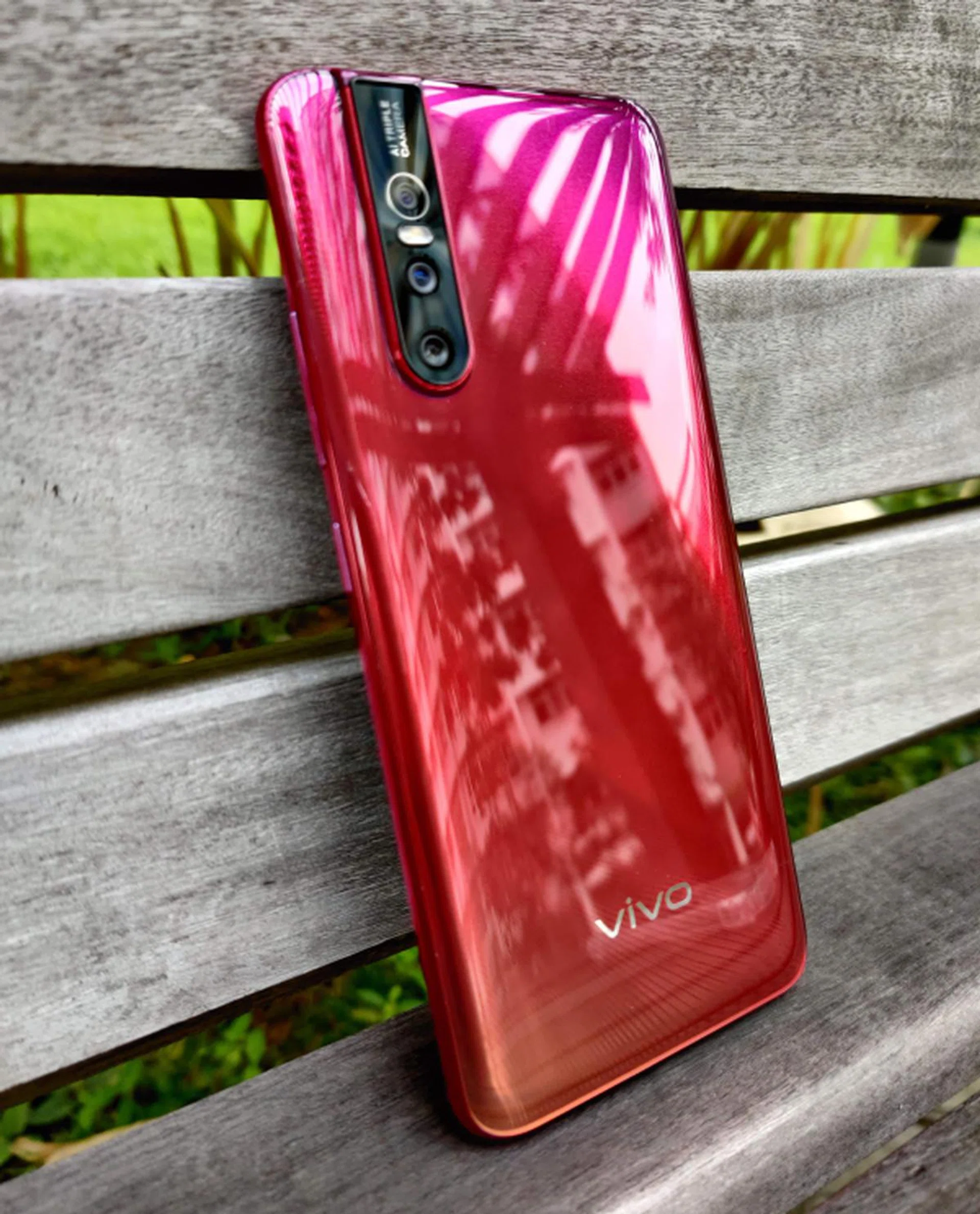 The back of the phone is very red. But sadly, it's plastic and not glass.