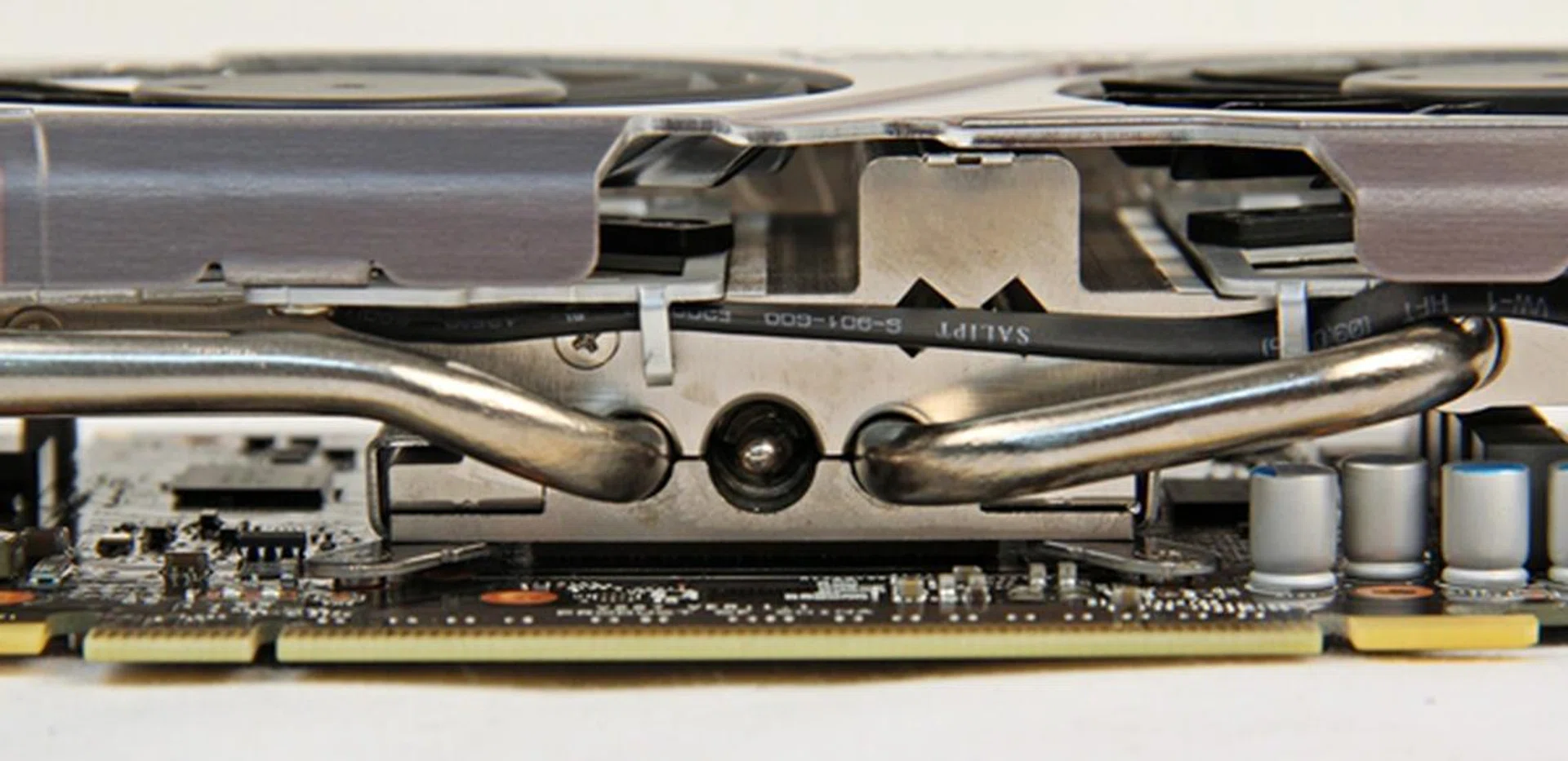 The GPU cooler sits directly on the GK106 core, and from this perspective, near the edge of the PCIe interface, we could see two of the three heatpipes that lead to the heatsink.