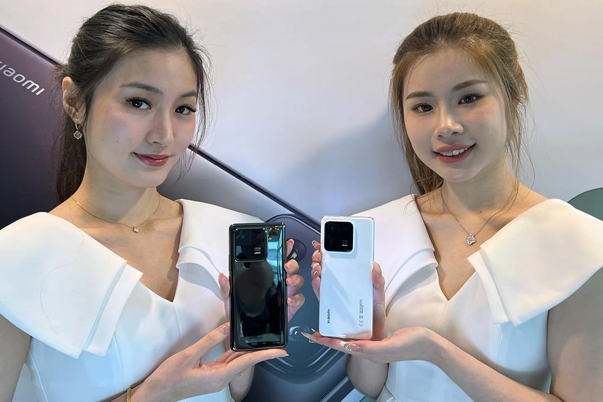 Models holding the Xiaomi 13 Pro in Ceramic Black (left) and Ceramic White (right).