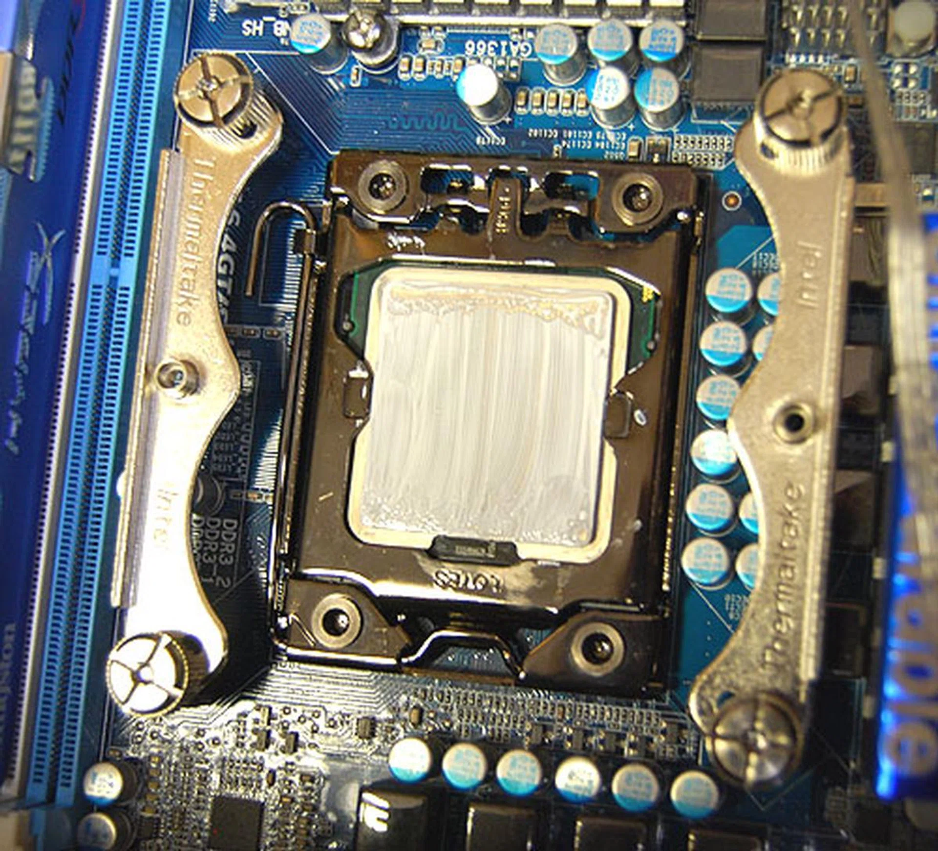 After fitting the backplate, it's time to screw in the mounting brackets for the cooler. In this case, for the Intel LGA1366 socket, there are two separate pieces. As you can see here, they don't interfere with the CPU latch, so you can change a processor without removing the bracket.