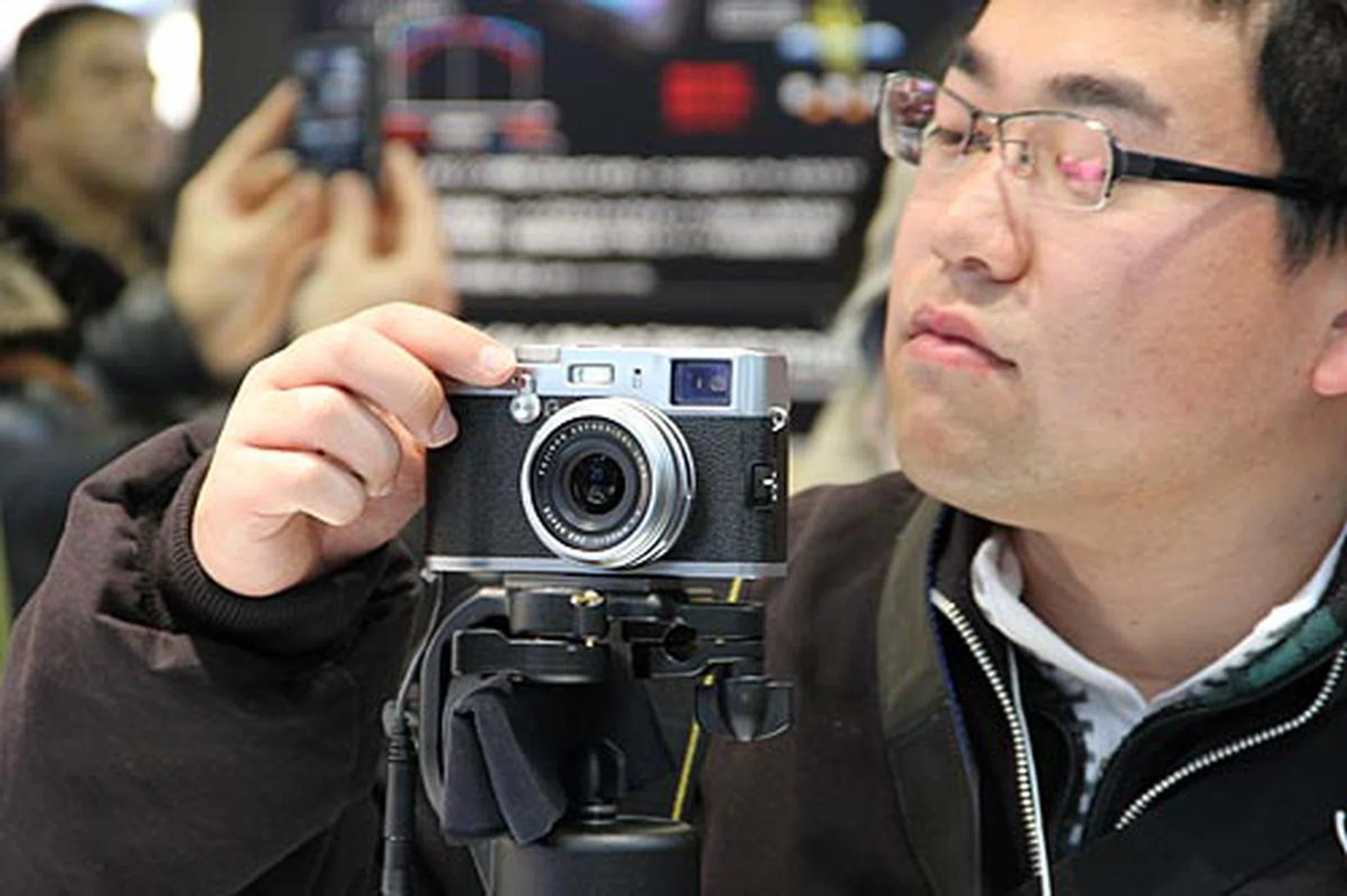 An attendee checking out Fujifilm's retro-looking FinePix X100. Despite its size, it has a 12.3-megapixel APS-C CMOS sensor. It also uses a 23 mm F2 FUJINON lens (35 mm in 35 mm equivalent), Fujifilm's EXR processor, as well as a hybrid viewfinder. And of course, analog controls for shutter speed, aperture and exposure compensation.