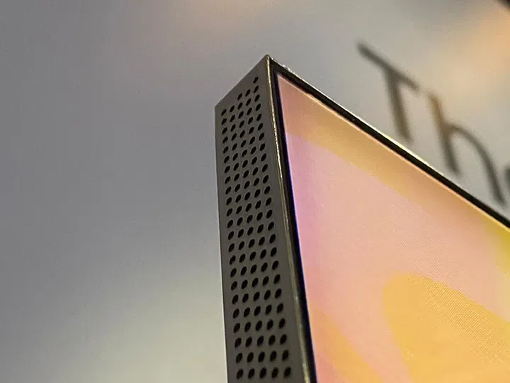 The holes on the metal sides of the Q950TS are the speaker holes. And as you can see, the bezel isn't completely gone, but it's super-thin (about 2mm).