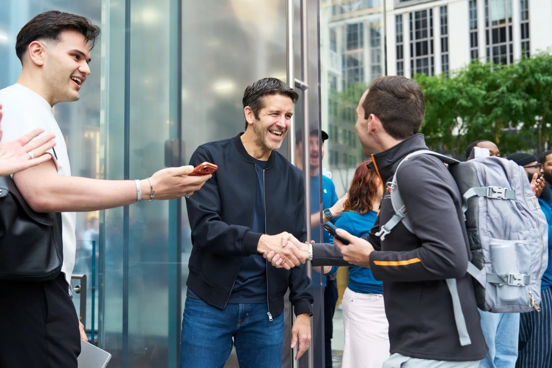 John Ternus welcomes a customer at Apple Fifth Avenue in New York for the launch of the latest generation of iPhone, Apple Watch, and AirPods.